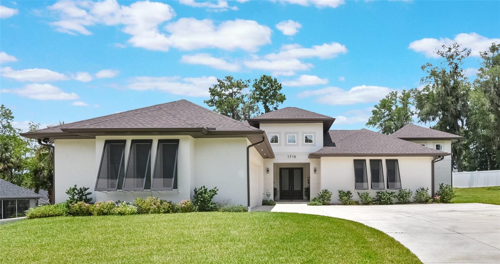This spectacular 4 bedroom 3.5 bath custom home in the heart of Ocala Florida was created for hospitality and built only 3 years ago on one of the highest elevations in the area. Surrounded by soaring pines and oak stands, you would never know that this community is in the center of town and only 5-7 minutes from all the finest restaurants and shopping Downtown provides. As you enter through the tall double doors, you are greeted by a resort style screened in courtyard complete with maintenance free turf, porcelain tiled breezeways, Waterfall, outdoor kitchen, and a covered dining area with a large screen TV and seating for six guests. Now step inside the main house and discover the open concept layout with the oversized kitchen sharing the space with the coastal inspired great room featuring tongue and groove wood cathedral ceiling with integrated surround sound speakers, a floor to ceiling fireplace complete with a 70” big screen TV plus a 9 ft long wet bar complete with beverage refrigerator. The flooring throughout the house is a wood plank ceramic tile tough enough to withstand the heaviest traffic and yet easy to maintain. The kitchen’s focal point is a uniquely shaped island with dark blue cabinets that seat six guests in a way that encourages engaging interaction. The rest of the kitchen cabinets are floor to ceiling in maple with quartz counters complemented by Bosch S/S appliances. Enjoy the butler’s pantry as a coffee bar or as a secondary food prep area that includes plenty countertop and storage space. The en-suite boasts a generous bedroom area with two large walk-in closets furnished with custom closet shelving and drawer systems. The spa inspired primary bath features an oversized walk-in shower complete with a free-standing soaking tub, frameless glass enclosure, dual effect shower heads and floor to ceiling dimensional tile. The two remaining bedrooms in the main house share a jack and jill bathroom adorned with wood cabinets and granite counters with double undermount porcelain sinks. The fourth bedroom is detached from the main house but connected by the breezeway. The “Casita” is accessed through double French doors and can serve either as a fourth bedroom or an office. This private space includes a closet and a full bathroom and is set up with an independent climate and audio control. The house boasts two driveways capable of easily accepting eight vehicles plus two more parked in the oversized garage. Other features include 10 ft ceilings, six zone audio system, automatic irrigation, Ring cameras, smart lighting dimmer switches, hot water recirculating pump system, network with WIFI extenders and home security for peace of mind. The community of Cala Hills offers a pool, fitness center, weight room, tennis courts and a club house. We invite you to tour this unique home in a quiet part of Florida which we call” The horse capital of the world.” BTW if you decide to come the sunsets are spectacular.