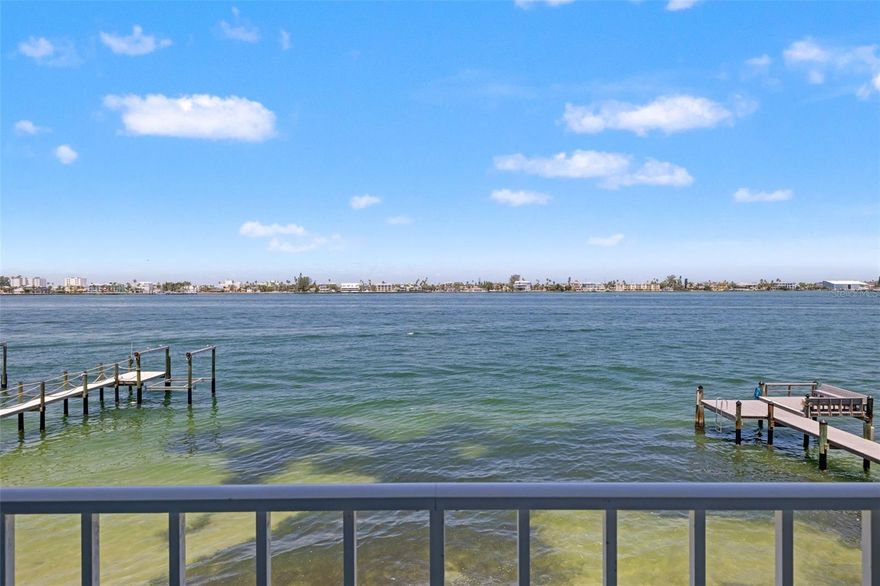 Stunning CORNER WATERFRONT CONDO with Panoramic Pass-a-Grille Channel Views!  Experience luxury waterfront living in this completely RENOVATED corner condo at the exclusive 9-unit Flamingo Bay Club in Tierra Verde. With 180-degree panoramic water views, this 2-bedroom, 2-bath residence defines living the Florida lifestyle — where breathtaking sunsets and abundant marine life are part of your daily life.  The condo has been meticulously redone with impeccable attention to detail throughout. Highlights include elegant Spanish porcelain tile floors, HURRICANE IMPACT WINDOWS, and an open-concept floor plan. The spacious living room features a wood-burning fireplace, while the chef’s kitchen boasts quartz countertops, custom wood cabinetry, stainless steel appliances, induction cooktop, and custom LED lighting. The primary suite offers direct balcony access, a custom walk-in closet, and a spa-like ensuite bath with dual vanities and a walk-in rain shower. Step outside to the expansive 50-foot balcony and enjoy sweeping views of the Pass-a-Grille Channel, Shell Key, Pass-a-Grille Beach, and the iconic Don CeSar Hotel. Additional features include an OVERSIZED 1-CAR GARAGE plus two extra parking spaces, a private dock with kayak lift, a tropically landscaped pool, and recent community upgrades including a NEW SEAWALL and DOCK. Perfect as a full-time residence or coastal getaway, this stunning waterfront condo offers the very best of Tierra Verde living.