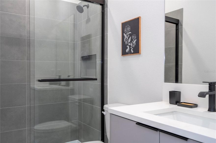 Short Sale. Fully upgraded from floor to ceiling, this luxury townhome blends contemporary elegance with high-end functionality — designed specifically for short-term rental success. Located in the exclusive Doppio Westside community in Kissimmee, just 15 minutes from Walt Disney World, this 5-bedroom, 4.5-bath home features an open-concept layout with spacious integrated living, dining, and kitchen areas that flow seamlessly to your own private heated pool.
The kitchen is a showstopper with two oversized islands, Level 5 quartz countertops, designer backsplash, slatted wood detail, and Whirlpool stainless steel appliances. All cabinetry throughout the home includes soft-close features and matte hardware for a sleek, modern finish.
Each of the five bedrooms is designed with comfort and rental flexibility in mind — including four full en-suites and one located on the first floor. The bathrooms are finished with high-end porcelain tile, glass shower enclosures, built-in niches, and vessel sinks in select locations. Luxury vinyl plank flooring runs throughout the entire home — no carpet anywhere — and 5.5" square baseboards give a clean, elevated look.
Additional features include PVC windows, a smart front door lock, a lockable owner’s closet, a hybrid water heater, EcoBee smart thermostat, and a two-car driveway. Construction is full concrete block, including second floor, with an insulated "sandwich" roof system and rubber membrane roofing designed for durability and energy efficiency.
Located within a gated community, Doppio Westside offers resort-style amenities such as a lagoon-style pool, full-service restaurant, clubhouse with front desk concierge, fitness center, playground, convention center, and EV charging stations — all exclusively zoned for short-term rental with no public school restrictions.
Don't miss this opportunity to invest in one of Central Florida’s most unique STR communities — fully upgraded as standard, and built with both guest experience and investor return in mind.