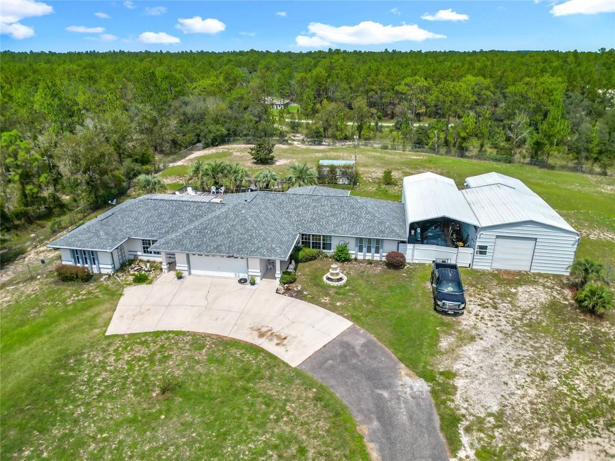 Live big on 2.48 fully fenced acres in Rainbow Lakes Estates—where privacy, flexibility, and endless possibilities meet. This rare multi-structure property includes a 3/2 main home, a 2/1.5 guest house with its own kitchen and patio, an in-ground pool, and a massive 4,000+ sq. ft. workshop that’s a showstopper.

Inside the main home, enjoy a bright open layout, cozy gas fireplace, and a spacious primary suite with walk-in closet. The guest house is ideal for extended family, visitors, or income potential. Outdoors, relax by the pool, bring your toys, or let pets roam in the cleared and fenced acreage.

The workshop features oversized bays, a lift, RV/boat storage, and even a small unfinished apartment—perfect for a future office or studio. Multiple covered parking pads and an RV garage complete the package.

Located in a quiet community with no HOA, residents enjoy access to the clubhouse, parks, playgrounds, walking trails, sports courts, and a community lake for boating and fishing. This is a one-of-a-kind property that combines space, freedom, and opportunity—schedule your private showing today!