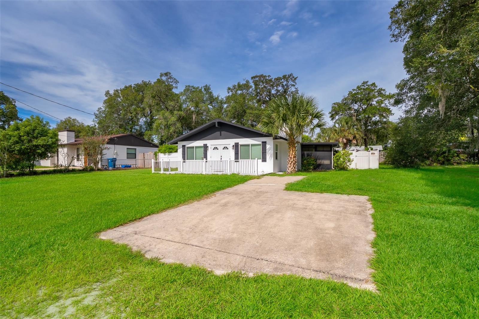 Welcome to 571 James St, Orange City, FL 32763 – a charming home with modern upgrades and a private oasis in the heart of a quiet, dead-end street! This property offers the perfect blend of comfort and convenience, with no HOA restrictions.
Step inside and be greeted by an inviting open-concept living space featuring vaulted ceilings and beautiful laminate flooring that extends throughout much of the home. The spacious living room boasts a stylish stone accent wall with a fireplace, creating a cozy ambiance. Natural light floods the interior through well-placed windows, and recessed lighting adds a touch of modern elegance.
The updated kitchen is a highlight, offering ample cabinetry, sleek countertops, and a full suite of stainless steel appliances, including a refrigerator and dishwasher. Two stylish pendant lights hang over the kitchen island, perfect for casual dining or meal prep. A striking dark wood beam runs across the vaulted ceiling, adding character and warmth to the main living areas, complemented by a large, modern ceiling fan.
This home features a well-appointed bathroom with contemporary finishes, including a modern vanity, a sleek toilet, and a shower/tub combination enclosed by a glass sliding door. Built-in wooden shelves provide convenient storage.
Beyond the main living areas, discover a versatile Florida room with a unique wood-tiled floor and expansive windows, offering abundant natural light and views of the private yard. This space is perfect for a home office, recreation room, or an additional living area.
The dedicated laundry area is both functional and stylish, boasting eye-catching patterned tile flooring, cabinetry for storage, and space for a washer and dryer.
Outside, your private retreat awaits! The fully fenced yard features an inviting in-ground pool, perfect for cooling off on warm Florida days. A paved patio surrounds the pool, providing ample space for lounging and entertaining, complete with a patio umbrella for shade. The property also includes a well-maintained grassy area and a convenient stone pathway leading to a shed for additional storage. The exterior of the home has been refreshed with a clean, modern look, including dark shutters against a refreshed facade and a welcoming front porch with a contemporary railing.
Enjoy peace of mind with a new roof installed in 2022 and a newer water heater.
Located just 1.3 miles from the renowned Blue Springs State Park, this home offers easy access to outdoor recreation. You're also approximately an hour from Disney World and just 40 minutes from Florida's beautiful beaches, making it an ideal location for both relaxation and adventure. Don't miss the opportunity to own this updated pool home in a serene Orange City neighborhood!