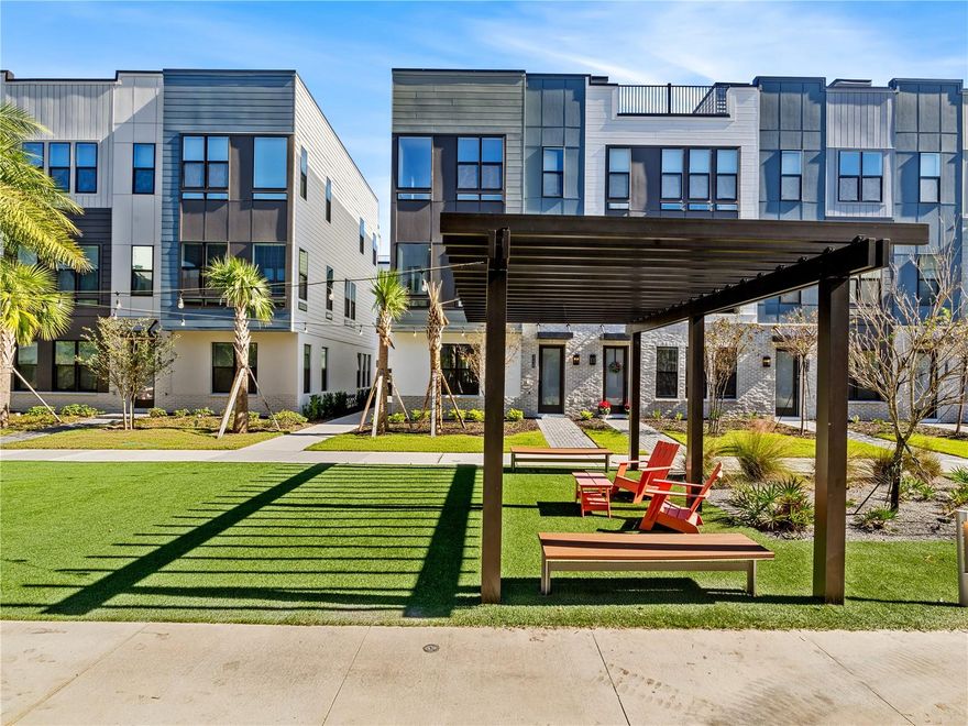 One or more photo(s) has been virtually staged. Ready to Move In, Ready to Impress! Welcome to your new home in the Brix community! A beautifully designed 4-story townhome with style, space, and a rooftop retreat that’s built for living and entertaining. On the first floor, you’ll find a private bedroom with its own ensuite bath, perfect for guests, a home office, or a quiet escape, plus a roomy two-car garage for all your storage and parking needs. Head upstairs to the second floor, where everyday life gets a serious upgrade. The gourmet kitchen features striking grey-blue cabinets, sleek quartz countertops, a crisp white backsplash, and a full suite of included appliances. The open layout connects the kitchen to a cozy dining area and a sunlit great room, the perfect space to unwind, entertain, or do a little of both. The third floor offers privacy and comfort with a spacious primary suite, a secondary bedroom, and a walk-in laundry room that keeps everything within reach but out of sight. But what really sets this home apart? The private rooftop terrace on the fourth floor, already wired and prepped for a future summer kitchen, fireplace, and hot tub. Whether it’s brunch with friends or quiet nights under the stars, this rooftop is your personal escape. Thoughtfully selected interior finishes bring style and function together: Engineered hardwood stairs, Luxury vinyl plank flooring throughout the main living areas, Designer cabinetry and quartz surfaces that make every space feel custom. And don’t forget, there’s a model home on-site with a similar layout and design. Stop by for a tour and see what life at the top really looks like. Living in The Packing District means so much more than just having a beautiful home — it’s about embracing a dynamic, connected lifestyle. Start your day with a peaceful walk or bike ride along the scenic 1.5-mile trail, then grab a slice at the food hall or break a sweat at the brand-new YMCA. Meet up with friends for a competitive game of pickleball or tennis at the Orlando Tennis Center — all just steps from your door. And the amenities don’t stop there. The Packing District is growing into one of Orlando’s most exciting new communities, featuring a new Publix, rock climbing facility, Hotworx Studio, and the innovative 4Roots Farm Campus. With future office and retail spaces also in the works, everything you need — from wellness to convenience to recreation — is right at your fingertips.