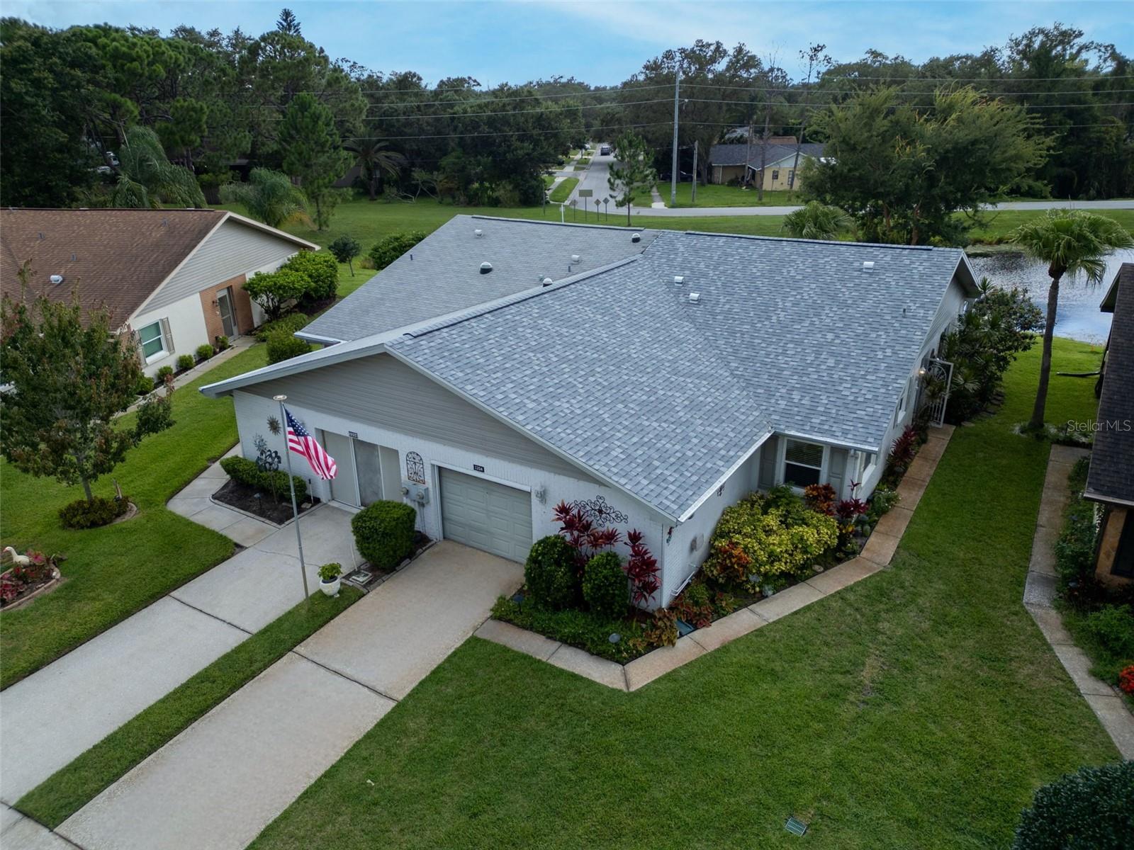 Welcome to this beautifully updated villa in Palm Harbor’s premier 55+ golf community of Highland Lakes! This stunning home features soaring vaulted ceilings, brand NEW luxury vinyl flooring, updated windows, and a brand NEW 2025 roof, offering peace of mind and timeless style. Perfectly positioned in one of the community’s most desirable locations, the villa backs to tranquil green space and peaceful water views with no immediate rear neighbors, providing ultimate privacy. The bonus fully enclosed lanai is not included in the heated square footage of the home, but is a peaceful & relaxing space to enjoy year-round. The thoughtful split floor plan centers around a spacious, modern kitchen with updated cabinetry, a built-in pantry, abundant counter space, newer appliances, and a cozy eat-in nook for casual dining. The expansive master suite is a true retreat, boasting generous closet space and an updated en suite bath with a walk-in shower. Pet-friendly Duplex Village II offers the lowest monthly fee in Highland Lakes—just $163/month—including cable, internet, lawn service, irrigation, trash, recycling, and pest control. Plus, a recent 4-point inspection has been completed and is transferrable to the buyer. Roof (2025), HVAC (2017), and updated electrical panel and storm windows! Located in a non-evacuation zone and safely above the flood plain, this home offers security and convenience. Residents of Highland Lakes enjoy a vibrant, country club lifestyle for only $164/month, with unlimited golf on three private executive courses, tennis, pickleball, bocce, and shuffleboard, a dynamic clubhouse with entertainment and fitness classes, and a lakeside lodge on Lake Tarpon with a private boat ramp, fishing pier, and community pontoon boats. Additional perks include free RV and boat storage and a fully golf cart-friendly neighborhood. Close to award-winning beaches, shopping, dining, top medical facilities, sports venues, and international airports, this rare Highland Lakes gem offers elegance, comfort, and effortless living—ready for you to move in and enjoy today!