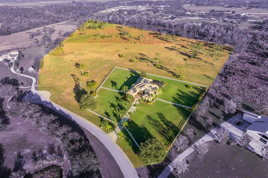 Welcome to 16002 Cutting Horse Trail, a stunning property located in the highly sought-after Sarasota Ranch Club. This rare gem offers a serene and tranquil setting, allowing you to escape the hustle and bustle of everyday life while still being close enough to enjoy all the cultural amenities and beautiful beaches that Sarasota has to offer. Situated on a sprawling 20 +/- acre parcel, this estate is perfect for those seeking a peaceful country lifestyle. Numerous golf courses minutes away along with the new Soleta golf course being built.
The gated equestrian community boasts miles of scenic bridle trails, allowing you to explore the natural beauty of the surrounding area. With its high and dry grazing land, this property is ideal for horse enthusiasts or anyone who appreciates the beauty of nature. No detail has been overlooked in this exceptional residence, custom-built by renowned builder Lee Wetherington. From the moment you step inside, you will be captivated by the impeccable craftsmanship and attention to detail. The interior features four bedrooms and three and a half bathrooms, providing ample space for comfortable living. Designed with both functionality and aesthetics in mind, this home offers a seamless flow between indoor and outdoor living spaces. The resort-style pool and spa create a luxurious oasis where you can relax and unwind on those warm Sarasota evenings. The spacious outdoor kitchen, living, and dining areas are perfect for entertaining friends and family or simply enjoying alfresco meals surrounded by lush greenery. 
Car enthusiasts will appreciate the convenience of the four-car garage, which is split into two separate spaces, allowing for flexibility in use. Additionally, this property features a wine room, a whole house generator ensures that you'll never be without power during unexpected outages, while the whole house solar system helps reduce your carbon footprint. Additionally, the tankless water heaters provide an endless supply of hot water, and the citrus trees add a touch of natural beauty to the landscape.
Don't miss your opportunity to own this exceptional property in Sarasota Ranch Club. With its idyllic location, impeccable craftsmanship, and an array of desirable features, this home is sure to appeal to the most discerning buyer. Schedule a showing today and experience the charm and tranquility that awaits you at 16002 Cutting Horse Trail.