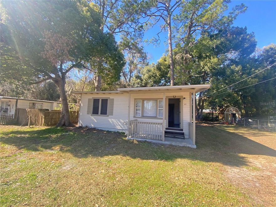 Welcome to this charming 1932 cottage that blends historic character with fresh modern updates! This adorable 2 bedroom, 1 bathroom home offers 720 sq. ft. of efficient, comfortable living space and is move-in ready. Step inside to find a bright and refreshed interior featuring brand new paint, updated vinyl flooring, and new carpet in bedrooms. The cozy electric fireplace provides warmth and charm, while 3 window A/C units help keep the home cool and comfortable year-round. The home features a covered front porch that adds to the home's classic curb appeal and provides a welcoming entry. Just off the kitchen, the covered back porch serves as a convenient utility space with washer and dryer hookups and hot water heater placement, helping maximize interior living space. The home offers a cute shaded backyard that provides plenty of room for relaxing, pets, gardening, or outdoor entertaining, along with a nice front yard. Location is a major highlight! Conveniently located just minutes from US Hwy 301, this home provides easy commuting access to Gainesville, Jacksonville, and Ocala, making it appealing for both homeowners and rental investment opportunities. Founded in the mid-1800s, Starke is known for its preserved historic downtown and welcoming community atmosphere. Residents enjoy hometown festivals, local dining favorites, and strong community connections that just might make you call Starke HOME.