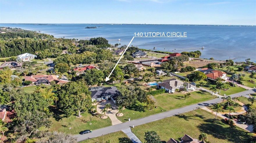 Luxury coastal living on 1-acre + a boat slip in Merritt Island. This home has it all: 4 beds, 4 full baths, a huge circular driveway, a pool, and an 864 sq ft garage. Soaring 14 & 10 ft ceilings throughout, abundant natural light, and a statement fireplace. A new metal roof (2025), gutters, and solar attic fans are just the first of many updates. Wide plank luxury vinyl flooring, stylish kitchen and baths, and LED lighting in every room create a spacious entertaining showcase. Completely redone low-maintenance tropical landscaping and stunning 40-year-old oak trees create a private, shaded oasis in the front and back fenced yards. Enjoy a private screened pool and deck, making entertaining a breeze. You'll love the spacious master suite featuring a coastal vibe, en suite bath, new double vanity, sconce lighting, and two huge walk-in closets. This home has exclusive use of slip #7 in the community marina, with its own private 8,000-lb boat lift (new 2022), providing direct access to the river/ICW.  An extra-long 864 SF garage includes two bays plus bonus space. A rare blend of acreage, updates, garage space, and premier boating access is ready to be yours.