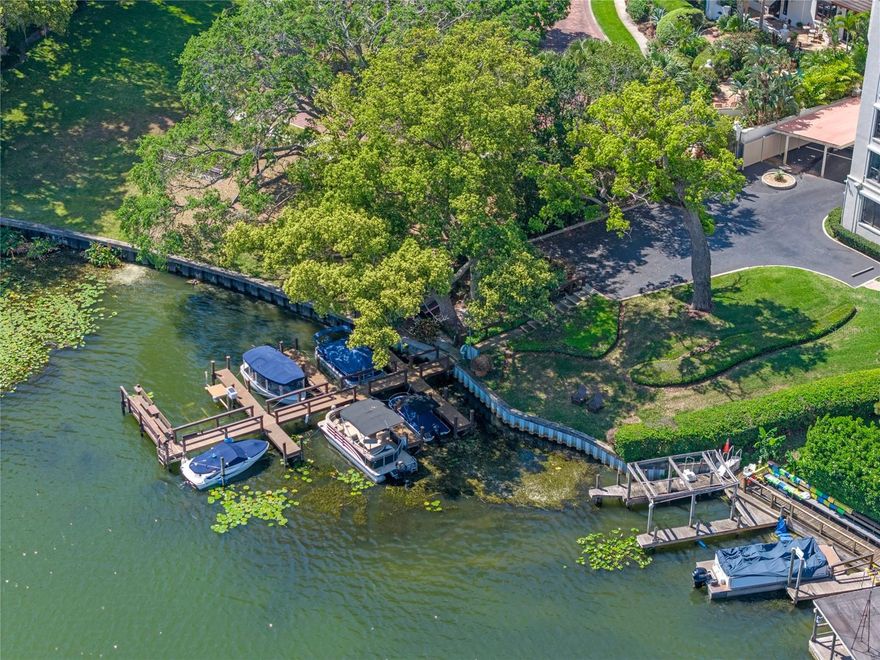 Welcome to The Cloisters, an exclusive lakefront enclave located in the heart of Winter Park, offering a rare combination of walkability, lakefront serenity, and bespoke design. Situated on the fourth floor, this fully reimagined residence is the result of a meticulous, full-scale renovation by W Designs LTD and has never been occupied.
A striking entry sets the tone with a black-and-white harlequin marble floor foyer and hall spilling into the main living area, where large-format Calacatta Gold floors extend through the kitchen and living spaces. Rich, solid wood custom-made floor-to-ceiling paneling wraps the living and dining room walls, complemented by cove crown molding and hand-crafted ceiling beams. Curated lighting fixtures finished in gilded gold leaf elevate the interiors with architectural distinction throughout this penthouse-style space, casting a warm, refined glow.
Hardware selections, ranging from fluted pulls to vintage door knockers, are crafted in solid brass and serve as both decorative and functional highlights, adorning the custom wood cabinetry and eight-paneled solid wood high-gloss lacquered doors.
The kitchen balances form and performance, featuring custom-built solid wood cabinetry with integrated lighting above and below, a peninsula of touch-latch lower cabinets facing the living area, and an adjacent beverage center. Pure quartzite stone countertops, a solid brass bridge faucet, and a paneled Fisher & Paykel refrigerator marry beauty with functionality, completing this design-forward culinary space. A full laundry is discreetly housed behind custom millwork in the kitchen.
The primary suite offers complete visual harmony and luxurious comfort. Ebony-toned herringbone wood floors run underfoot, with black high-gloss interior doors and custom closet systems clad in solid wood and quartzite. A bespoke floating vanity sits just outside the en-suite spa-like bath. Plate glass mirrors showcase the all-marble space, which includes a walk-in glass shower enclosure with multiple showerheads, including a rain fixture and handheld, and a floating solid wood vanity with quartzite counters and solid brass fixtures.
The second bedroom, equally refined, features Oxford gray grasscloth wallcoverings and a custom-framed window. Brass hardware adorns the closet doors. Adjacent, the secondary bath continues the theme of luxury with handcrafted black marble flooring, a soaking tub with marble surround, a floating vanity, and a handcrafted custom gold faucet by Phylich that provides a bespoke finish.
A screened private balcony extends the living space outdoors, offering views of lush gardens, the community pool, and Lake Osceola beyond.
Additional features include an assigned covered parking space and access to a private storage unit. The Cloisters offers a comprehensive suite of amenities, including onsite property management, elevators, ample guest parking, a putting green, heated pool, private lake access, resident boat slips via lottery, two fitness centers with dry sauna, and a newly renovated clubhouse with full kitchen and bath.
Located just a short stroll from the boutiques, dining, and cultural offerings of Park Avenue and Rollins College, this boutique residence delivers custom new-construction quality, unmatched design, and an ultra-rare walkable lakefront lifestyle.
