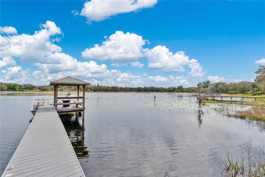 This private Lakefront home sits on 1.6 acres close to the Orlando Health Horizons West Hospital, 429 Beltway, Hamlin Grove shopping and Disney. A Peaceful place to come home to located in the Avalon Equistrian community off Avalon and Seidner Road. This Tri Level, Lakefront home is directlly on the 184 acre private Lake Avalon with it's own dock for your boat! The 2,800 sqft home has 4 bedrooms, 4 bathrooms and a flowing floorplan that invites the outside in. The large backyard and paver patio is great for outside dining, watching the glow of fireworks from Disney and Florida's incredible sunsets.  This home has so many amenities, it is hard to list them all. The 1.6 acre lot has room to park two 40 foot motorhomes (with dedicated electric power) and a fenced area for pets. There's a 2 car garage and a 75 ft Trex dock with gazebo built in 2021. There is a Mother-in-Law suite on the ground floor has a separate entrance, kitchenette, bath and plenty of storage. Other buildings include a 20x20 ft block building with water, AC, and plumbing, a 10x20 shed and a 6x8 greenhouse. This home was renovated in 2018 with new AC, water heaters and a solar system. The Roof, new floors, kitchen and bathrooms were replaced in 2020. There is also a whole house 2200 watt propane generator still under warranty, and there are 2 years left on the transferrable Choice Home Warranty. The HOA fees are just $50 per year, with 2 newsletters. Equal Opportunity Housing. Come home to your new piece of tranquil Florida!