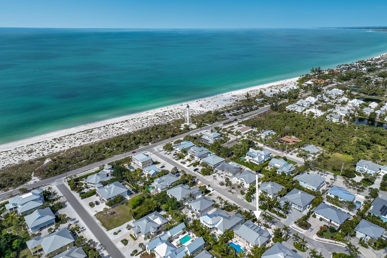 Boasting an idyllic location in the heart of Boca Grande on Gasparilla Island, this beautifully appointed 2016 home just south of town presents unparalleled opportunity for those seeking the perfect blend of elegance, comfort, and coastal charm with the benefits of newer construction. This four bedroom, four bathroom residence is beautifully positioned on a 80’ x 135’ south facing lot creating an incredibly generous and private outdoor pool space with sunshine all day long! As you enter this Island home you’ll appreciate the maintenance free composite decks and freshly sealed tongue and groove outdoor cypress ceilings. Once inside, the high ceilings, large impact glass windows, and open floor plan with gorgeous European white oak engineered flooring throughout, creates an airy and welcoming atmosphere. The three dormers over the living room space create eye catching architectural interior design, soaring ceilings, and the natural light abounds into the living room that also features recessed sliding glass doors to the outdoor deck overlooking the pool. The chef’s kitchen features luxury Thermador appliances including a Professional Series 6 burner gas range and double oven, refrigerator, dishwasher, and U-Line wine refrigerator. The kitchen island is graced with seating for four, a timeless marble countertop and white porcelain apron front sink with quartz countertops on the perimeter. Retreat to the spacious primary suite with modern bespoke bathroom with a frameless shower door, soaking tub, walk-in closet, and charming french doors that lead to the exterior deck overlooking the tropical outdoor oasis. This thoughtful split floor plan offers three guest bedrooms and bathrooms with a fun bunk bedroom en-suite featuring custom lighting with USB outlets/charging ports for each bed space. The exterior of the home is protected with impact glass windows and doors, Hardie-board siding and soffits, and a 2016 metal roof. Relax by the 36’ x 14’ pool with sun shelf or entertain on the expansive patio with propane powered grill and fire pit all while surrounded with mature, tropical landscaping, providing a true, private, Island paradise. The recently painted garage bays offer freshly coated epoxy floors and owners and guests love this beautiful Island street with buried utilities. With views of the iconic range light from the semi-circular driveway, beach access at the end of the street, close proximity to town, restaurants, shops, and farmer’s market, this timeless Island residence ensures a seamless blend of convenience and luxury.