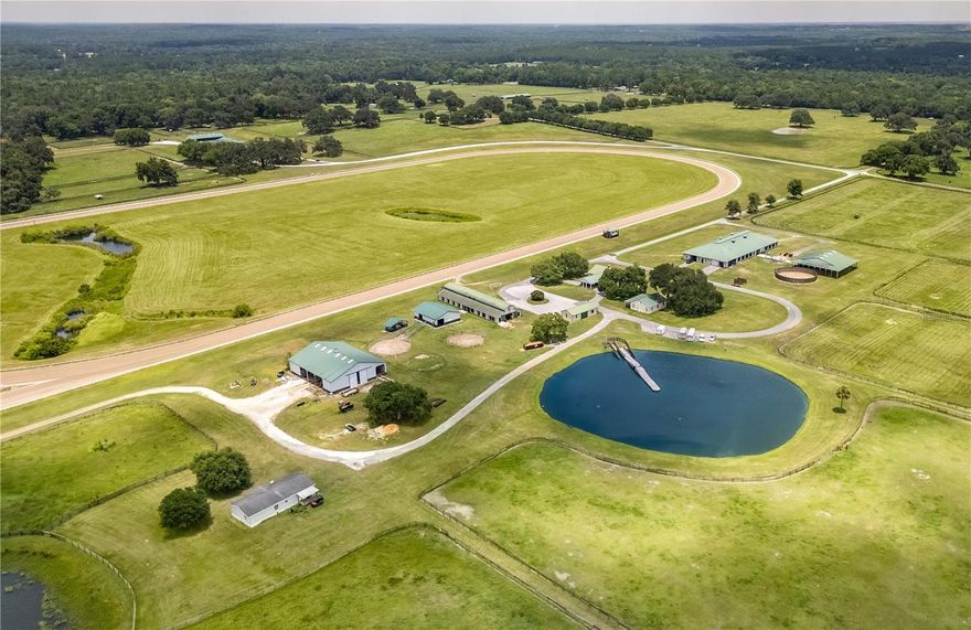 This extraordinary training facility is nestled in the Farmland Preservation Area of NW Ocala's prestigious horse country, just 27 minutes from the World Equestrian Center! Spanning 413+ meticulously maintained acres, this exceptional farm offers a wealth of features for the discerning equestrian. A picturesque oak-lined paved drive welcomes you to this state-of-the-art facility, boasting one of the area's only 7/8 mile tracks, complete with irrigation and a viewing stand. The property includes six barns: a 36-stall training barn, an 18-stall training barn, three barns with 24 stalls each, and a 12-stall barn. Each barn is equipped with its own unique features, which includes tack and feed rooms, hay and equipment storage, wash racks, bathrooms, and even an office/pharmacy, ensuring every need is met. Additional amenities include a spa building with another two stalls, two Eurosizers, a Theraplate, equine pool with dock, round pens, and multiple storage, maintenance, and workshop buildings. Living accommodations are equally impressive, featuring a main home at the top of a hill with stunning views of the track, a "bunk house" with three studio apartments, an additional 3-bedroom, 3-bath manager’s residence, living quarters in some of the barns, and a double-wide mobile home. With easy access to a variety of tack and feed retailers, world-class veterinary care, and many equine service providers throughout the area, this property provides the perfect balance of convenience and potential. This unparalleled horse farm  is the epitome of Central Florida equestrian excellence, perfectly designed for equestrians looking for year-round training opportunities.
