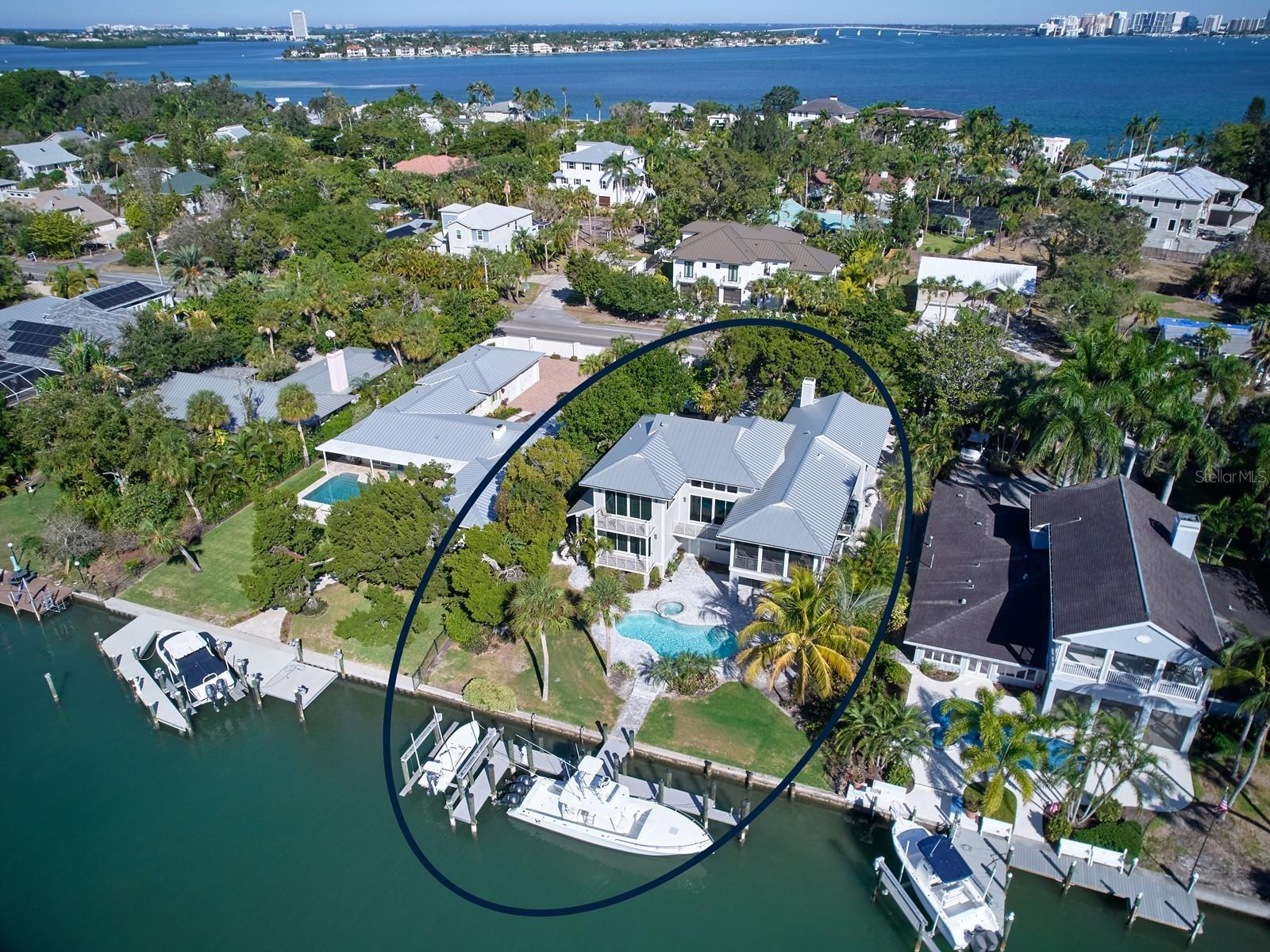 <i>**Be sure to view the <b>immersive 3D floor plan</b> by visiting our <b>state-of-the art virtual tour.</b>**</i><br>A MODERN SIESTA KEY HOME ON DEEP SAILBOAT WATER! This luxurious residence, revitalized to meet today’s standards, beckons to those yearning for their own waterfront paradise. The custom multi-level home offers 4 full bedrms, & 3.5 baths. A convenient elevator accesses all four levels. Expansive water views set the stage in the main living area w/ its own balcony, 2-story ceilings, & clerestory windows. The upgraded tile flooring flows elegantly into the eating space w/ an attached covered & screened veranda, the perfect place for al fresco dining. Adjacent a contemporary kitchen has been remodeled w/ new coastal inspired furniture quality cabinetry, stone counter tops, a vegetable sink, a breakfast bar, a planning center, & high-end stainless-steel appliances; a Sub Zero refrigerator, Fisher Paykel dishwashers, a trash compactor, a GE Café double convection wall oven w/ a warming drawer, built-in wine refrigeration & a microwave. The 6-foot cooking island has matched cabinetry & twofold cascading stone surfaces & a Wolf brand gas cooktop w/ a stainless-steel hood. A large walk-in pantry has additional storage space. Nearby are a lavish powder rm w/ Onyx for guests & a fully equipped laundry rm. The formal dining rm has an open wall & flexibility of use. Hardwood flooring flows gracefully from this rm into the den/study or family rm. Handcrafted built-in shelving surrounds the gas fireplace here w/ vaulted ceilings & a front overlook balcony. The penthouse floor is comprised of only the Owner’s Suite. Serenity envelops the private chambers & includes a waterside balcony w/ views. 2 facing California-style walk-ins connect the spa-inspired personal bath. Retreat & rejuvenate in the jetted tub encased w/ soft lighting. The glass enclosed walk-in shower has both an overhead rainfall nozzle & secondary faucet. Separate vanities each have their own hammered copper basins, & LED lighted mirrors. A water closet, stone tiles, a skylight, & recessed linear LED lighting add the fishing touches. 2 full bedrms w/ a middle bath can be found at the entry level of the home. Bonus millwork includes crown moldings & wainscoting. Elevating the interior entertainment amenities are a ground level bedrm suite (w/ a pool bath entrance), a large walk-in closet, & a recreation rm. Sliding glass doors open to extend the living space onto the covered patio overlooking the saltwater pool & spa. Brick pavers have been laid by hand poolside all the way down to the water’s edge. 'Custom Dock & Davit' reconstructed the dock that accommodates 2 vessels w/ a boat lift for a 25-foot vessel & will house another boat up to 38-FT. W/ great water depth (8-foot in channel at low tide), there are no fixed bridges from the protected waterway directly to the ICW, Big Pass & or the Gulf of Mexico. All decking has been upgraded to Trex composite boards. A climate controlled 3-car garage w/ an insulated door & an extra storage rm enters from the side via an extended paver brick drive. Improved w/ a whole house generator, four zoned a/c units, impact rated doors & windows w/ remote controlled treatments. A new standing seam metal roof, lush tropical foliage & walled privacy further enhance the island lifestyle afforded by this North Siesta Key home. Please note that security cameras are in use. Room Feature: Linen Closet In Bath (Bedroom 2). Room Feature: Linen Closet In Bath (Bedroom 3). Bedroom Closet Type: Walk-in Closet (Primary Bedroom). Room Feature: Linen Closet In Bath (Bedroom 4).