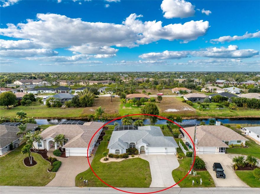 A Poolside Retreat with Peaceful Canal Views in Rotonda West’s Golf Community! Welcome to relaxed Florida living in this beautifully maintained three bedroom, two bathroom, three car garage pool home, ideally located in the X flood zone and equipped with Storm Smart shutters throughout along with hurricane rated garage doors for added peace of mind. Set back nicely from the road, the home offers generous parking for family and guests, while mature landscaping and arched windows create inviting curb appeal. Inside, the open floor plan features split bedrooms, volume ceilings, and triple pocketing sliding glass doors that frame serene pool and canal views. Tile flooring flows through the main living areas and bathrooms, while the bedrooms feature low maintenance luxury vinyl plank flooring for easy everyday living. The spacious kitchen offers an abundance of white cabinetry, solid surface countertops, a walk-in pantry, and a breakfast bar. The adjoining dining area includes an additional set of sliding glass doors, making it easy to extend gatherings outdoors and enjoy seamless indoor to outdoor entertaining. The ensuite primary bedroom is a private retreat with tray ceiling, bay wall, sliding doors to the pool, and two walk-in closets. The primary bathroom features a soaking tub, walk-in shower, and separate dual vanities, providing plenty of space for both privacy and comfort. Both guest bedrooms include walk-in closets, and one offers direct access via sliding doors to the pool and screened lanai. The guest bathroom also serves as a pool bathroom and features a tub and shower combination. Outdoor living truly shines with a large screened lanai complete with a heated pool, ceiling fans, outdoor shower, and mature landscaping thoughtfully designed to provide privacy. Just beyond the pool, the canal invites you to drop a fishing line, kayak, or simply relax while enjoying the peaceful sounds of visiting birds and wildlife. Additional features include workbench and built-in shelving in the garage, canal fed irrigation, the interior was repainted within the past year, and newer and modern style lighting fixtures and ceiling fans throughout. This home is ideally located near everything that defines the Florida lifestyle, including boating, beaches, golf courses, pickleball, hiking trails, nature walks, and the Placida Fishing Pier. You are also close to the Cape Haze Pioneer Trail, a paved rail trail following a former railroad corridor that offers easy biking through natural scenery and wildlife. Rotonda West is a deed restricted community known for its twenty six miles of canals, along with ponds and lakes that attract abundant fish and wildlife. Residents enjoy a wide range of recreational activities including golfing, boating, fishing, tennis, hiking, and a variety of clubs and social groups. Located at 443 Rotonda Circle, this home offers the perfect blend of comfort, lifestyle, and location for enjoying the very best of Florida living.