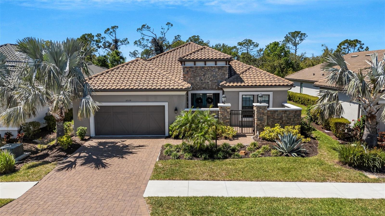 Discover your dream home in the prestigious Legacy Estates, where luxury meets comfort in a resort-style setting. This exquisite property features a private courtyard and boasts high ceilings with an open floorplan, perfect for modern living and entertaining. With three ensuite bedrooms and ample linen closets, this home offers both privacy and convenience. The interior showcases numerous upgrades, including LPV flooring, crown molding, and tray ceilings, elevating the aesthetic appeal throughout. The chef's kitchen is a culinary delight, equipped with upgraded stainless-steel appliances, a French door oven, granite countertops, a convenient pot filler, and a large center island. Whether you're hosting friends and family or enjoying a quiet evening, the open floor plan allows for seamless interaction. Open the two large hideaway sliders to reveal your backyard oasis, perfect for outdoor living. Relax by the tiled gas fireplace under the expansive covered lanai, complete with an outdoor kitchen, and take a dip in the one-of a kind lagoon style ,saltwater pool surrounded by mature trees for ultimate privacy. Legacy Estates is renowned for its world-class amenities, including tennis, pickleball, bocci, a beautiful resort pool, a resistance pool, spa, cabanas and a fun splash pad area for the kids. Stay active or unwind with a massage or train in the well-equipped gym, and enjoy socializing at the pool side Bahama bar, featuring weekly live music and various activities. With on-site management organizing a full schedule of events, you can truly enjoy the tranquility of home while experiencing a vacation lifestyle every day.
Don’t miss this opportunity to own a piece of paradise in Legacy Estates—where every day feels like a getaway!