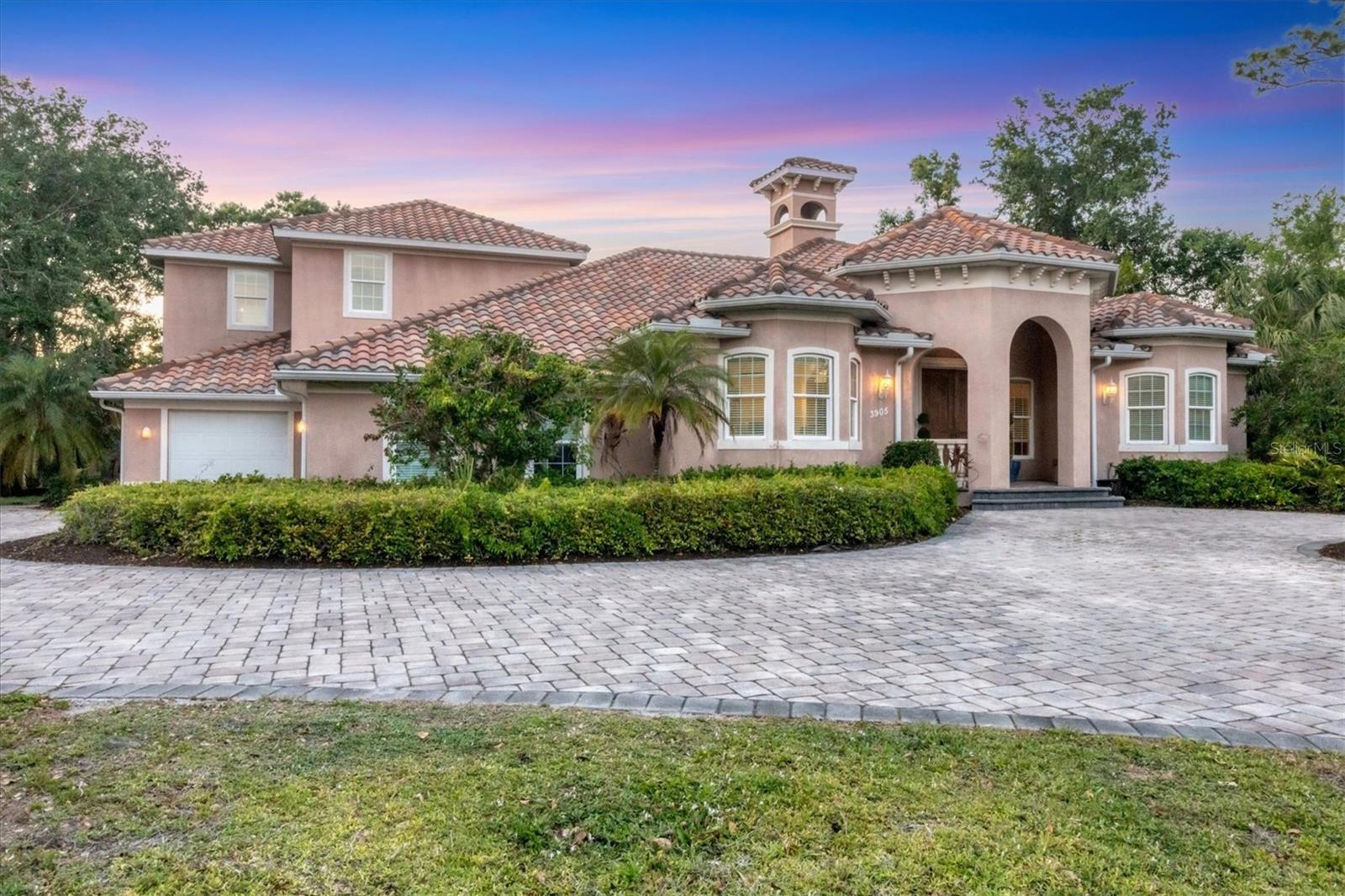 **Seller Motivated: An Opportunity Not to Be Missed!** Welcome to your dream home in the desirable Ravenwood community! This custom built 4-bedroom, 2-bathroom and 1 half bath residence offers an impressive 3,891 square feet of living space with a whopping 5,100 square feet under the roof total, providing ample room for relaxation, separation, and entertainment. Set on a spacious 1-acre lot, you will enjoy tranquility and privacy provided by lush tropical foliage and a fenced dog run, all for an affordable HOA fee of just $222 per year. As you enter, you are greeted by a spacious living room with lit double trey ceilings and a separate dining room that flows seamlessly into the chef’s kitchen, complete with granite countertops featuring dual lazy susans in cupboards and dedicated appliance compartments. The charming glass cabinet doors and pull-out spice drawers add a touch of elegance to this well-appointed kitchen, which boasts a breakfast bar for six perfect for family gatherings. A walk-in pantry, conveniently tucked under the stairs, provides ample space for all your gadgets, while the laundry room features both upper and lower cabinets, counters, and a sink for your convenience. The half bath serves guests off the kitchen near the eat-in kitchen that opens up to a spacious family room, where friends and family can cheer for their favorite sports teams or engage in a competitive game of billiards. Step outside to the expansive lanai, complete with a built-in 2022 BBQ kitchen, ideal for entertaining. Whether you prefer basking in the sun or seeking shade under the ceiling fan, this space is perfect for hosting swims in the large pool or relaxing in the jacuzzi. Retreat to the master suite located on the second floor, featuring a spa-like bath and a custom walk-thru closet. The second floor also includes a versatile 4th bedroom, perfect as a sitting room, office, or guest bedroom. On the east wing of the first floor, two spacious bedrooms can be conveniently closed off for guests, ensuring privacy and comfort while sharing a dual-entry oversized bathroom. Additionally, the side-entry two-car garage and separate one-car garage offer plenty of space for vehicles or even that unique project you’ve been dreaming of. Built in 2009 hurricane-proof windows and doors were installed and located in an X flood zone, this home combines modern amenities with peace of mind. Two HVAC units installed in 2024 ensure the ideal indoor climate. With a prime location, you are just minutes away from University Town Center, connecting you to the interstate, or head West to the beautiful beaches and downtown Sarasota. This property truly is an oasis in the heart of town—don't miss your chance to make it your own!
