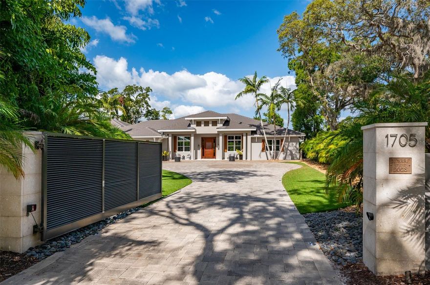 Welcome to 1705 Wisconsin Lane - a truly luxurious estate located in the coveted crossroads of West of Trail and the North Siesta Key Bridge in Sarasota.

This stunning property sits on over half an acre of land, encompassed by lush Florida landscaping and offering complete security through its gated entrance. Every aspect of this estate is enhanced by smart technology, allowing seamless control of all features right from your phone.

As you enter through the gate, the majestic exterior facade will greet you. Landscaping lights guide your way to the west side of the home, where you'll find a remarkable 5+ car climate-controlled garage. Designed with the car enthusiast in mind, these garages boast vacuum systems, professional-grade Swiss Tracks flooring, and both have Mitsubishi in-wall air conditioning systems.

The main home itself spans almost 4,000 square feet, providing an ideal setting for Florida coastal living. With 4 bedrooms, 4 full bathrooms, 2 half bathrooms, and a spacious office, there is ample room for all your needs. The kitchen is a chef's dream, boasting Viking appliances, abundant storage, and an inviting atmosphere.

The owner's suite is truly an oasis, offering open views of the heated and self-sanitizing saltwater pool and spa. The space is sprawling, featuring a foyer with its own wet bar and wine fridge, three separate walk-in closets, and an in-wall safe. The owner's bathroom exudes a spa-like ambiance and includes electric shades for added privacy.

Each bedroom is accompanied by its own ensuite bathroom, thoughtfully maximizing the main home's square footage. An added bonus room, the office, includes sliding barn doors, French doors, and an ensuite half bathroom that opens to the heated saltwater pool and spa.

This remarkable estate also includes a separate guest apartment situated above the detached garage. Ideal for hosting family or friends, this spacious living area with over 700 square feet provides privacy from the main home. Two sets of French doors overlook manicured palm trees and a beautifully paved driveway.

The entire exterior of this property is adorned with professionally installed landscaping lighting, adding a thoughtful and inviting touch.
The property includes a 22kw partial home generator by Generac, a tankless water heater for the main home, a separate water heater for the Guest Apartment, a Pentair gas heated saltwater pool and spa with self-sanitizing technology, complete smart home technology, landscape irrigation, a culligan filtration system in the kitchen, 2020 Mitsubishi air conditioners in each garage, 4 volt boxes to control elaborate landscape lighting, a pro vacuum system in each garage, 2016 HVAC system with a germicidal UV Light system, an in-wall BlumSafe for watches and jewelry, and wine fridges in the Office and Owner's Suite.

This home truly has it all - from its desirable layout and exceptional upgrades to its large gated lot, offering unparalleled privacy. And with its perfect location in proximity to Siesta Key and Downtown Sarasota, you'll have access to the best of both worlds.