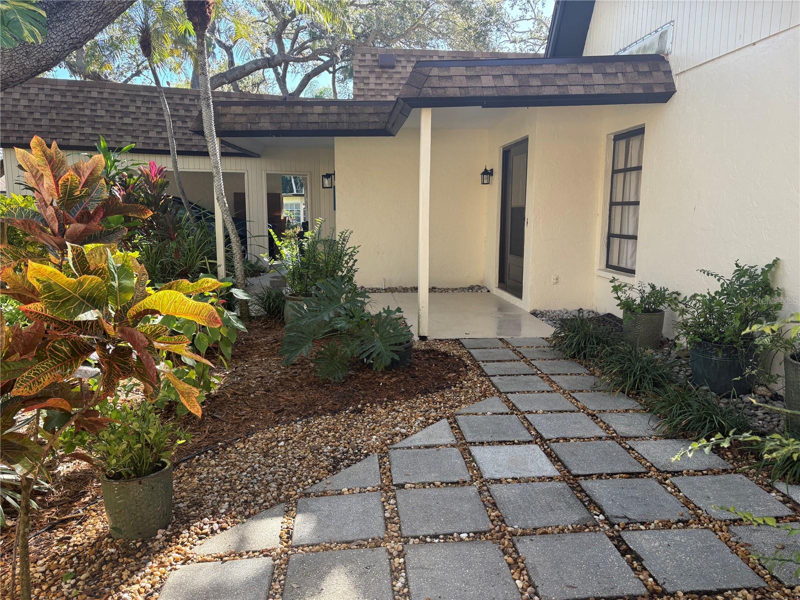 Upgrades galore in this stunning 2 bedroom 2 bath villa. Convieniently located near the pool and tennis / pickleball courts in the desirable neighborhood of Woodside Village East. Beautiful Travertine Marble floors throughout the unit. New HVAC unit (June 2025), updated bathrooms with generous use of stone. The spacious living room has vaulted ceilings, crown moulding and flows into the charming Florida room with an abundance of natural light. Updated Kitchen is completely open to the living space with granite and quartz counter tops with new dishwasher and refrigerator. Master bedroom was modified to close off the bathroom and create an alcove perfect for use as an office workspace. Walk in closet and sliders open to private patio. Spacious second bedroom with large walk in closet. Beautiful front garden with tiled area, great for outdoor entertaining. Dont miss this one, easy to show.