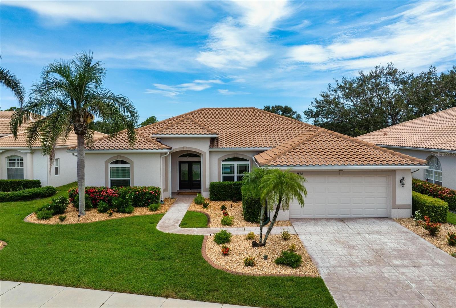One or more photo(s) has been virtually staged. Coastal-Inspired Renovation with Lake, Golf Course Views & Private Pool. Step into this renovated, coastal contemporary home where comfort meets peace of mind. 2-year-old tile roof, all hurricane impact-resistant garage door and windows (dining & primary bath), accordion shutters on all others. Freshly updated with light-toned luxury vinyl plank flooring throughout and soft Sherwin Williams Alabaster walls, the home feels fresh, bright, and welcoming. The kitchen and both bathrooms showcase handsome wood cabinetry with granite countertops, pull-out drawers, and clever storage features. The kitchen includes a counter-height breakfast bar, while the luxurious primary suite offers a spa-like retreat with dual vanities, a garden tub, frameless glass shower, and a professionally designed closet system. The open great room features 12-foot-wide pocketing sliding glass doors that seamlessly connect indoor living to the expansive screened lanai and heated pool, perfect for entertaining or quiet evenings overlooking the golf course. A thoughtful split floor plan ensures privacy, placing the owner's and guest suites on opposite sides of the home. Excess storage capacity built-ins in the garage, laundry room and interior living spaces. Enjoy worry-free living with lawn maintenance, high-speed internet, and expanded cable included in the HOA. The vibrant gated community offers 27 holes of semi-private golf, a full social membership, clubhouse dining, fitness center, tennis, pickleball, heated pool, and an active women's association with over 45 interest groups.