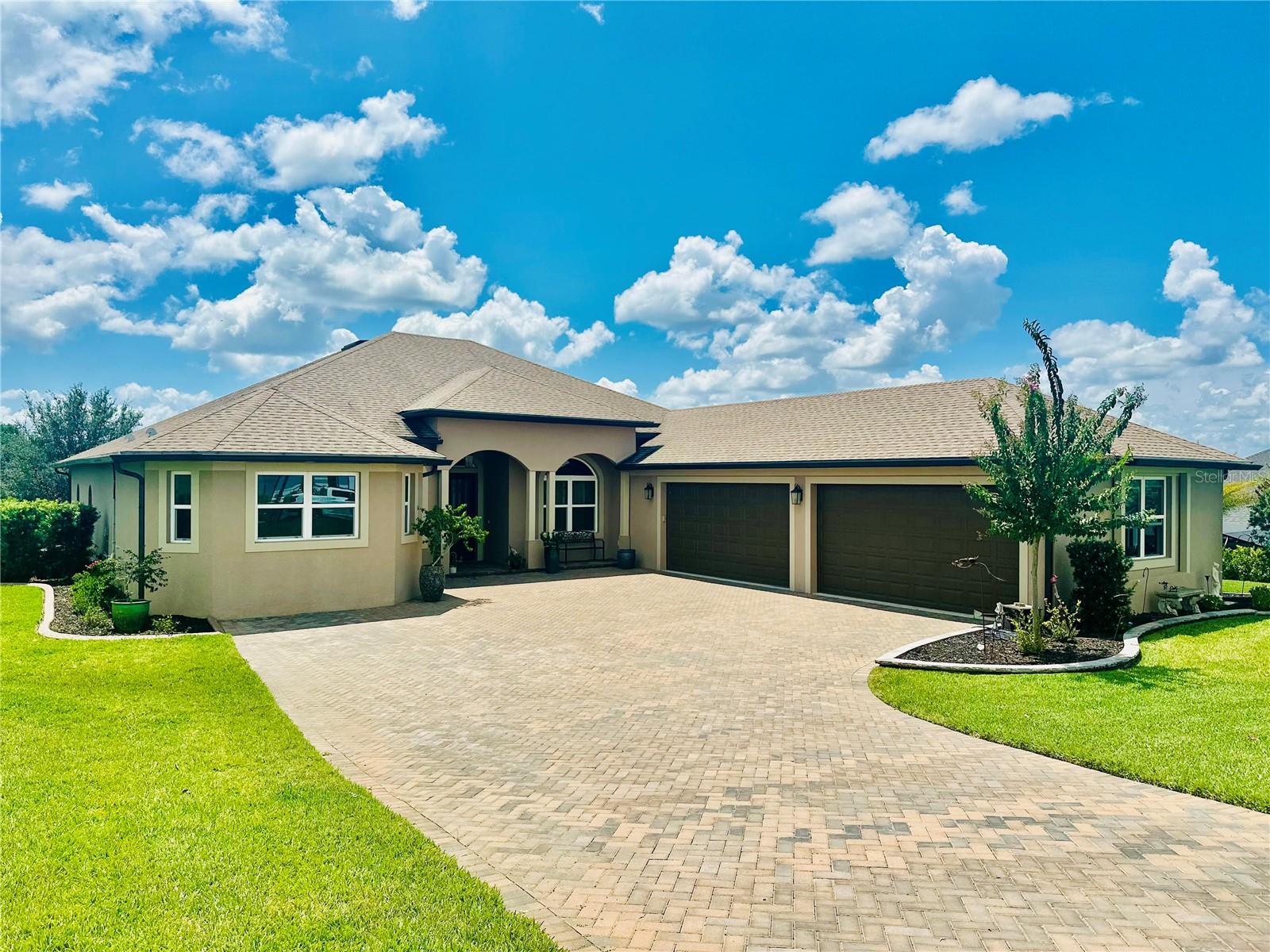 Experience luxury living in this impeccably upgraded 4 bed + Office + Bonus Room + 3 bath home with a rare 4-car garage, built in 2021 and located with a pond view on .48 acre in the desirable Harbor Hills Golf & Chain of Lake community. This one of a kind customized Willow Model featuring 3,432 sq ft heated is sure to impress. From the moment you step inside, you'll notice the soaring ceilings, elegant 6" baseboards, and 7.25" crown molding that add a refined touch throughout. Beautiful porcelain tile plank flooring spans the entire home, providing both style and durability. The chef’s kitchen is truly a showstopper—featuring a gas cooktop, large island with dual-sided cabinetry, upgraded appliances, stylish cabinetry and hardware, a designer tile backsplash, and an upgraded sink and faucet. Ample storage is available in the walk-in pantry and oversized appliance cabinet. All bathrooms have been thoughtfully upgraded with premium countertops, cabinetry, sinks, faucets, and comfort-height toilets. The spacious primary suite (26 x 15) includes a luxurious en suite bath with dual vanities and a large walk-through shower. Additional highlights include a spacious laundry room (6’6 x 20) with upgraded cabinetry and sink, a dedicated indoor storage closet, and an expansive screened lanai with peaceful pond views and ceiling fans for added comfort. This home is equipped for peace of mind with a 24 kWh whole-house generator and a 250-gallon in-ground propane tank, including a gas line to the outdoor grill area—perfect for entertaining. Located just minutes to shopping, restaurants, doctors, medical facilities, the Villages Square with nightly entertainment and so much more!!