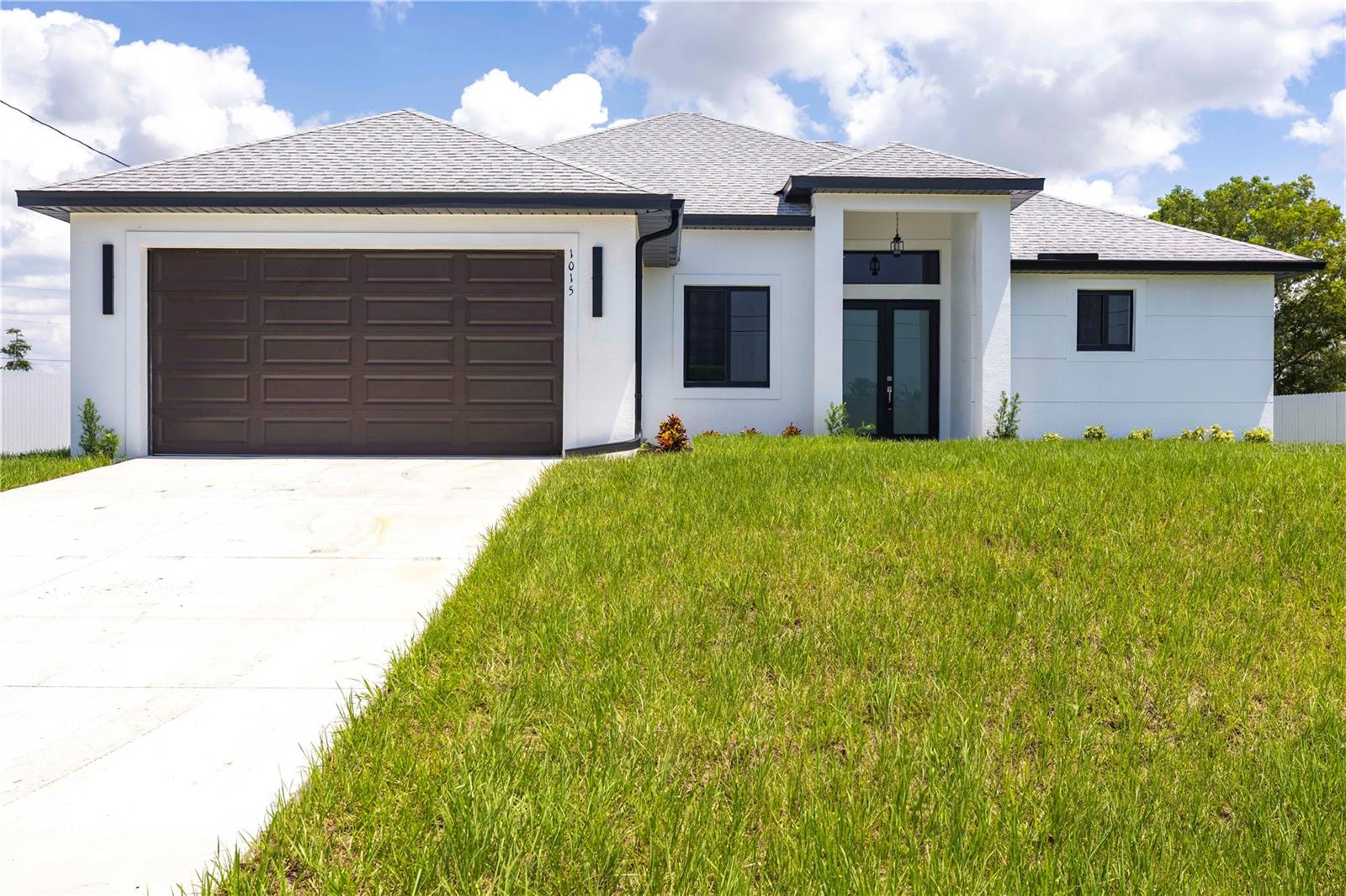 Welcome to this stunning 4-bedroom, 2-bathroom home offering 1,732 square feet of thoughtfully designed living space, located on a Corner Lot! Step through impressive 8’ impact-rated double front doors into a welcoming foyer that leads into the spacious open floor plan home. The bright luxurious living space is perfect for entertaining and everyday living! The kitchen boasts 9-4' Plywood cabinetry, a large center island with quartz countertops and waterfall quartz edges, complete with black on black matte finish Samsung appliances. Soaring 13’ ceilings in the great room and 9’4” to 12’ ceilings throughout the home create an open airy feel. The flexible layout includes a 4th bedroom that can easily serve as a home office. The master suite offers two walk-in closets and an en-suite bath with dual vanity sinks and a walk-in shower with multiple showerheads. At the back, 8’ impact-rated double doors lead out to a private tiled lanai ideal for entertaining. Additional features include a 2-car garage with 8 ft high grade door, and large format tile flooring throughout. Don’t miss your chance to live in this stylish and functional home — schedule your visit today! *Sample Photos