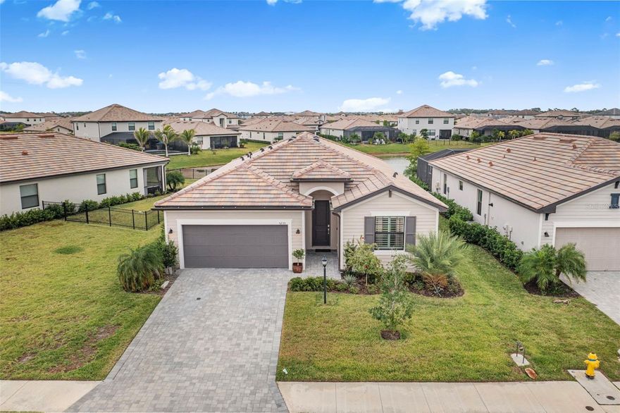 Experience relaxed lakefront living in the gated community of Lorraine Lakes at Lakewood Ranch. This inviting Trevi floor plan offers 4 bedrooms, 3 full baths, and over 2,000 square feet of thoughtfully designed space. From the moment you enter, you’re welcomed by an open layout filled with natural light and beautiful water views. The kitchen takes center stage with granite countertops, stainless steel appliances, a gas range, walk-in pantry, and a generous island that brings everyone together. The adjoining great room and dining area make daily living and entertaining effortless. The primary suite offers a quiet retreat with two walk-in closets and a spa-style bath showcasing a modern wet-room design, where a freestanding soaking tub is set within the walk-in shower for a sleek, spa-like experience. One of the guest bedrooms includes its own private en suite, ideal for extended stays. Plantation shutters, updated lighting, and warm neutral finishes complement the easy coastal design throughout. Outside, the sellers are enhancing the backyard by removing the pavers and extending the patio with a concrete deck and larger screened enclosure, perfect for relaxing or hosting gatherings overlooking the lake. Practical upgrades include a tile roof, paver driveway, epoxy-coated garage floor, and a tankless water heater. Lorraine Lakes provides a maintenance-free lifestyle with lawn care, internet, and cable included. Resort amenities abound, featuring resort and lap pools, splash zone, fitness center, indoor courts, tennis and pickleball, playground, putting green, tiki bar and restaurant, arcade, and a full-time lifestyle director who keeps the calendar full of activities and events. Outside the gates, Lakewood Ranch offers endless ways to enjoy life in motion. Explore miles of trails and parks, weekend farmers markets, outdoor dining at Waterside Place, live music at Main Street, and golf courses for every level of play. Top-rated schools, medical centers, and nearby beaches complete the picture of convenience and comfort. Here, every day feels like a getaway, and home is where the Florida lifestyle truly begins. **THIS PROPERTY QUALIFIES FOR A 1% LENDER INCENTIVE IF USING PREFERRED LENDER. INQUIRE FOR MORE DETAILS.**