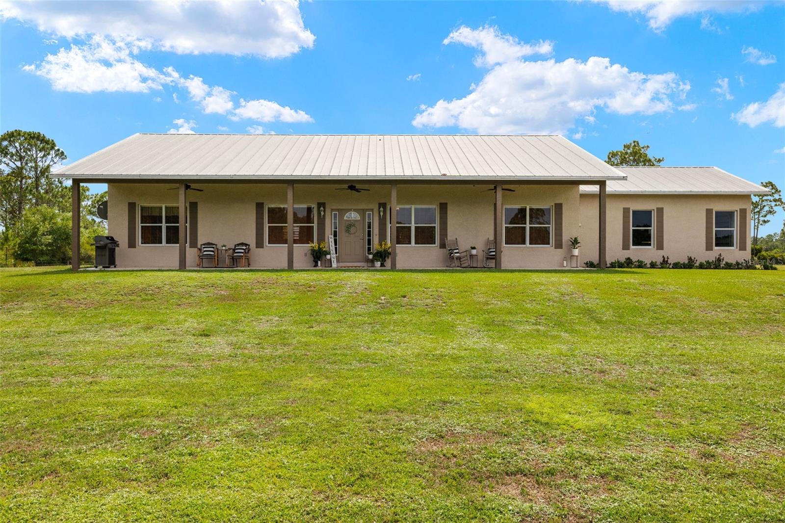 Tucked away on a peaceful 10.74-acre parcel, this captivating property offers the perfect blend of serene country living and modern comfort. Surrounded by a mix of lush woodlands and open pasture, the home is a private retreat just minutes from the conveniences of town. Whether you're dreaming of a small farm, an equestrian haven, or simply a quiet place to unwind, this land offers endless possibilities. Step inside to a light-filled interior where high ceilings and an open floor plan create a spacious and welcoming atmosphere. The sleek kitchen is a standout feature, boasting granite countertops, stainless steel appliances, and ample cabinetry—ideal for everyday meals or entertaining family and friends. Tile flooring throughout and large windows bring the outside in, enhancing the connection between the home and its natural surroundings. The fully fenced property provides abundant space for livestock, gardens, or recreational activities, while offering unmatched privacy and tranquility. The layout of the land makes it easy to envision your next steps—whether expanding the home, adding outbuildings, or simply enjoying the beauty of the space as it is. With its solid structure, inviting design, and rare combination of seclusion and accessibility, this property is a true gem in Southwest Florida. Come discover the peace, potential, and beauty this unique retreat has to offer.