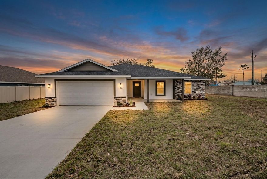 Freshly built and full of charm, this brand new 4 bedroom, 2 bath, 2 car garage home sits proudly
on a spacious corner lot just shy of a 1/3 of an acre in a lively and convenient Dade City location.
The curb appeal immediately catches your eye with a beautiful stone accent wall, modern
exterior paint colors, attractive landscaping, and a welcoming covered front porch that feels
made for a few rocking chairs and slow Florida evenings. Step through the front door and the
home opens up to an impressively spacious layout where the main living areas flow naturally
together, creating a comfortable entertainer’s haven. The living room feels bright and open with
high ceilings, a ceiling fan, luxury vinyl plank flooring, and triple sliding glass doors that lead
directly to the expansive covered back porch, bringing in plenty of natural light and extending
the living space outdoors. Just steps away, the eat-in kitchen serves as a stylish and functional
hub of the home. A large island with breakfast bar seating sits at the center, complemented by
pendant lighting, granite countertops, sleek stainless steel appliances, matte black fixtures and
hardware, pantry storage, and plenty of space for cooking and gathering. Nearby, a dedicated
dining room with a matching chandelier offers a perfect setting for sit-down meals and special
occasions. Between the kitchen and garage, the laundry room is thoughtfully placed for
convenience when bringing groceries inside. Two storage cabinets topped with granite
countertops add extra organization and create an ideal spot for additional pantry storage.
Privately located away from the secondary bedrooms, the oversized 12 x 19 primary suite feels
airy and inviting with abundant natural light and room to truly unwind. Two walk-in closets
provide excellent storage, while the ensuite bathroom impresses with dual sinks, vanity seating,
granite countertops, upgraded lighting, and a remarkable walk-in shower featuring two shower
heads, two-toned stone slab tile, matte black fixtures, and a built-in bench. On the opposite side
of the home, three comfortable guest bedrooms each offer luxury vinyl plank flooring, ceiling
fans, and built-in closets. They are positioned near the home’s second full bathroom, which
continues the home’s stylish finishes and includes a tub and shower combination. Outdoor living
is just as enjoyable from the large 26 x 11 covered back porch overlooking the expansive yard,
offering plenty of space to relax, entertain, or enjoy the partially fenced surroundings. All of this
is located just a short drive from downtown Dade City’s popular restaurants, shops, and local
attractions, while still offering convenient access to schools and major roadways. If you’ve been
waiting for a brand new home with space to spread out and a location close to everything, this
one is ready to welcome you. Call today to schedule your private showing!