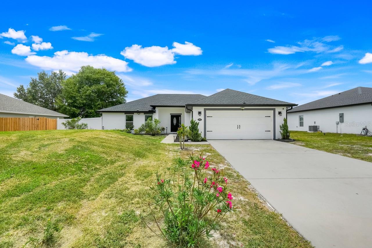 Welcome to this captivating 3-bedroom, 2-bathroom home built in 2021, offering 1,633 sq. ft. of elegant living spaceand loaded with modern upgrades throughout. Located in a quiet neighborhood in Deltona, this beautifully maintained property features an open floor plan, perfect for both everyday living and entertaining. Step into a welcoming foyer that flows into a spacious living room, complete with a coat closet and ambient movie lighting for cozy nights in. The gourmet kitchen is a true showstopper, featuring: Granite island with breakfast bar, Soft-close drawers, Stylish pendant lighting, Eye-catching backsplash and Coffee bar/wine bar for your morning brews or evening pours.The primary suite offers a relaxing retreat with a ceiling fan, movie lighting, dual walk-in closets, and a bathroom with granite countertops and a large walk-in shower. On the opposite side of the home, you’ll find the second and third bedrooms, both with ceiling fans, and a conveniently located hall bathroom. Additional features include: Bonus room, air-conditioned laundry room, Crown molding and paned windows throughout, Large screened lanai with two ceiling fans, Fenced-in backyard for privacy, complete with a shed, and Gutters already installed. This home truly has too many upgrades to list and is a must-see for buyers seeking comfort, and style. Located just minutes from shopping, dining, and easy access to I-4—perfect for commuters!