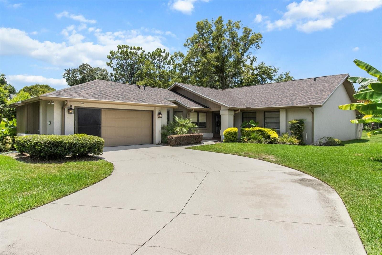 Imagine waking up to peaceful mornings overlooking the natural greenbelt from your sunlit, glass-enclosed Florida room. This charming 3-bedroom villa invites you to slow down and savor the view — or share it! With its spacious layout, vaulted ceilings, and maintenance-free lifestyle, this home is perfect as your personal retreat, a seasonal escape, or a desirable rental investment. The remodeled kitchen (2008) features warm wood cabinetry and striking black granite countertops, flowing into a cozy family room with built-in entertainment center — great for gatherings or guests. The owner’s suite surprises with unique Jack & Jill bathrooms and dual walk-in closets. The third bedroom transforms effortlessly with a built-in Murphy bed and custom desk, ideal for visitors or remote work. Enjoy peace of mind with a new roof (2014) and energy-efficient 16 SEER AC (2014). Additional perks include indoor laundry, newer appliances, an extra-large garage with screen, and a location close to shopping, dining, medical care, and endless recreation. Whether you keep it all to yourself or welcome paying guests, this villa is more than a home — it’s your invitation to live (or invest) life large!