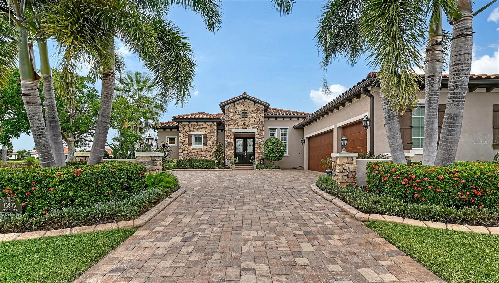 Positioned on a premier homesite with water on two sides and sweeping long-lake views, this John Cannon custom-built residence blends quality construction with timeless design. Hurricane impact glass, front and rear roll-down storm shades, and a whole-house generator provide peace of mind, while beautiful wood floors, solid core doors, crown molding, volume tray and coffered ceilings, plantation shutters, and built-in speakers elevate the interiors. At the heart of the home, the kitchen showcases a large center island with dinette seating, wine bar with wine fridge, stainless steel appliances, and a gas cooktop, opening effortlessly to the living and dining rooms for both everyday living and entertaining. The expansive primary suite features a double-door entry, tray ceiling, lanai access, spa-like bath with walk-in shower, dual vanities with makeup counter, and an enviable custom-designed closet. Thoughtfully arranged guest suites ensure privacy, while the versatile fourth bedroom with lanai access easily serves as an office or bonus room. Zero-corner sliders in the living room and multiple sets of sliders from the dinette extend the living space outdoors, where the lanai becomes an entertainer’s paradise—complete with saltwater pool and spa, full outdoor kitchen, and both lounging and dining areas framed by spectacular water views. Added highlights include a tankless water heater, landscape lighting, utility sinks in both the laundry room and garage, and countless other thoughtful details that make this home exceptional. Lakewood Ranch is the number one best-selling multigenerational community in the country and is located near world-class shopping, dining, and entertainment at Lakewood Ranch Main Street, University Town Center, and downtown Sarasota, with minutes to I-75, beaches, excellent schools, and medical facilities. Several levels of membership to the Lakewood Ranch Golf and Country Club are available and optional.