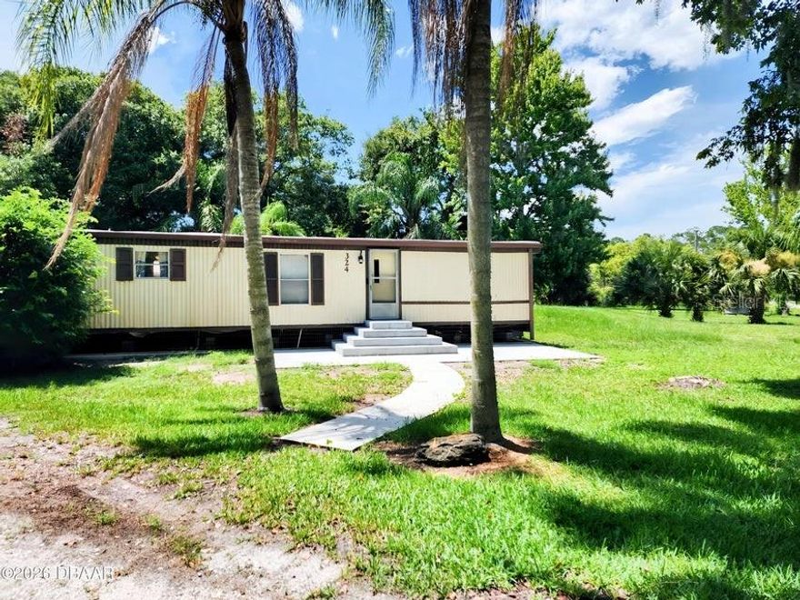 **OWN YOUR OWN LAND** 2 bedroom, 2 bathroom manufactured home situated on just under a half acre of privately owned land, offering added space and privacy with no lot rent. The home features title flooring throughout along with ceiling fan and light fixtures in multiple living areas for comfort and functionality. This property includes a partially fenced yard and a two-car carport with a concrete pad located at the rear of the home.