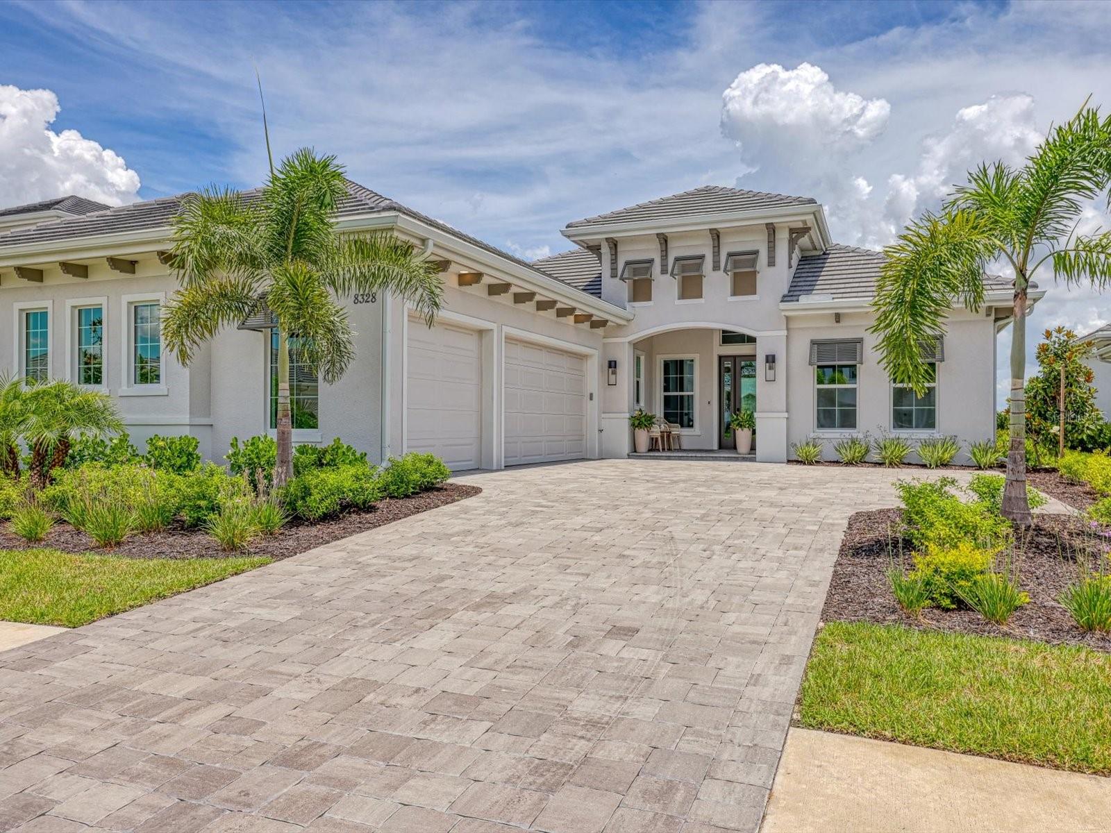 Welcome to Your Luxurious New Residence in Wild Blue at Waterside! This exceptional opportunity offers entry into Wild Blue at Waterside, one of Lakewood Ranch’s most prestigious new communities! This elegant residence offers over 3,000 square feet of living space, including four bedrooms, three and a half bathrooms, a formal dining room, and a private office/study. Exquisite Design & High-End Finishes Inside, the open-concept floor plan with soaring ceilings, designer lighting, and premium tile flooring throughout. The gourmet kitchen is a true showpiece, equipped with custom soft-close cabinetry, quartz countertops, a designer tile backsplash, a huge island, and top-of-the-line KitchenAid appliances. Adjacent, the great room features a sophisticated dry bar. The expansive primary suite offers dual walk-in closets, private French door access to the lanai, and a beautifully appointed en-suite bath with dual vanities, a soaking tub, and a luxurious walk-in shower. Step outside to an expansive covered lanai with a fully equipped outdoor kitchen, a saltwater pool and spa, and a clear-view screen enclosure showcasing tranquil water views. Additional features include impact-resistant windows and sliding glass doors, and a spacious three-car garage with epoxy flooring, offering both practicality and aesthetic appeal. This exquisite residence perfectly blends refined architecture, thoughtful design, and an unmatched location. An extraordinary opportunity to embrace the Florida lifestyle at its highest level. Additionally, homeowners will benefit from exclusive access to the nearby Midway Sports Complex, which includes tennis and pickleball courts, basketball courts, kayak launch, walking trails, dog parks, playgrounds, and covered pavilions. Ideally positioned in proximity to Waterside Place, the University Town Center (UTC), Lakewood Ranch Main Street, Sarasota-Bradenton International Airport, and the renowned beaches of Florida’s Gulf Coast, this residence combines both luxury and convenience.