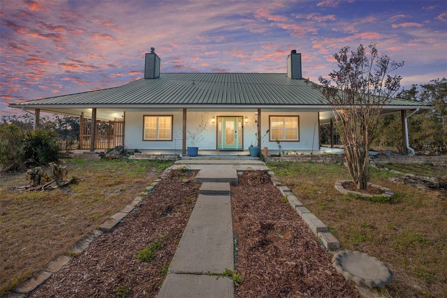 Five Fenced Acres. Custom Architecture. Expansive North Florida Skies.

Set on five fully fenced acres and surrounded by open pastureland, this custom built two story home offers privacy, scale, and presence in one of Newberry’s most serene rural settings.

With 4,974 square feet under roof and 3,170 heated square feet, this 3 bedroom, 2.5 bath residence delivers architectural character and functional space while remaining conveniently close to town and a short drive to Gainesville.

The 10 foot wraparound covered porch sets the tone immediately. Designed for morning coffee, long evenings, and open air living, this home was built to be experienced.

Inside, Brazilian Koa hardwood floors anchor the main level. The living room rises with warmth and volume, centered around a striking wood burning fireplace that creates a natural gathering space. A loft overlooks the living area and offers flexibility for a fourth bedroom conversion, executive office, or secondary living space.

The kitchen was built with both scale and intention, featuring custom wood cabinetry with roll out drawers, two wall ovens, a gas cooktop, nearly 25 feet of granite counter space, an oversized 8 foot island, and two separate pantries.

The primary suite is expansive and private, complete with its own gas fireplace and a true 10 by 10 walk in closet. The en suite bath features an iron claw foot tub, a 5 by 7 glass enclosed shower, and a separate water closet.

Step outside and the setting becomes the defining feature. Fully fenced and usable acreage offers room for horses, gardens, hobby farming, or simply the freedom that comes with open land. Surrounded by ranch properties and minimal light pollution, evenings here offer wide horizons and stunning star filled skies.

No HOA. No congestion. Just land, privacy, and possibility.

Opportunities offering five fenced acres, custom construction, and this level of seclusion at this price point are increasingly rare.

Private showings available.