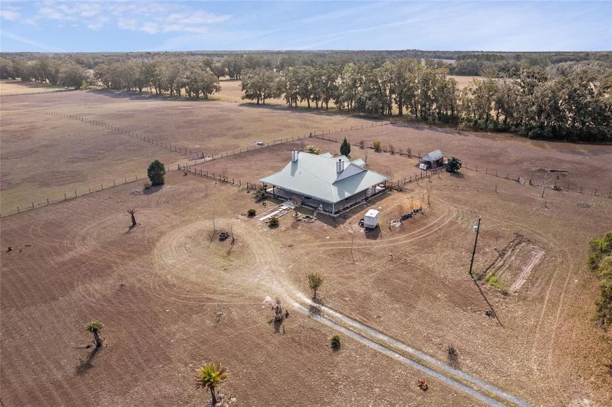 Five Fenced Acres. Custom Architecture. Expansive North Florida Skies.

Set on five fully fenced acres and surrounded by open pastureland, this custom built two story home offers privacy, scale, and presence in one of Newberry’s most serene rural settings.

With 4,974 square feet under roof and 3,170 heated square feet, this 3 bedroom, 2.5 bath residence delivers architectural character and functional space while remaining conveniently close to town and a short drive to Gainesville.

The 10 foot wraparound covered porch sets the tone immediately. Designed for morning coffee, long evenings, and open air living, this home was built to be experienced.

Inside, Brazilian Koa hardwood floors anchor the main level. The living room rises with warmth and volume, centered around a striking wood burning fireplace that creates a natural gathering space. A loft overlooks the living area and offers flexibility for a fourth bedroom conversion, executive office, or secondary living space.

The kitchen was built with both scale and intention, featuring custom wood cabinetry with roll out drawers, two wall ovens, a gas cooktop, nearly 25 feet of granite counter space, an oversized 8 foot island, and two separate pantries.

The primary suite is expansive and private, complete with its own gas fireplace and a true 10 by 10 walk in closet. The en suite bath features an iron claw foot tub, a 5 by 7 glass enclosed shower, and a separate water closet.

Step outside and the setting becomes the defining feature. Fully fenced and usable acreage offers room for horses, gardens, hobby farming, or simply the freedom that comes with open land. Surrounded by ranch properties and minimal light pollution, evenings here offer wide horizons and stunning star filled skies.

No HOA. No congestion. Just land, privacy, and possibility.

Opportunities offering five fenced acres, custom construction, and this level of seclusion at this price point are increasingly rare.

Private showings available.