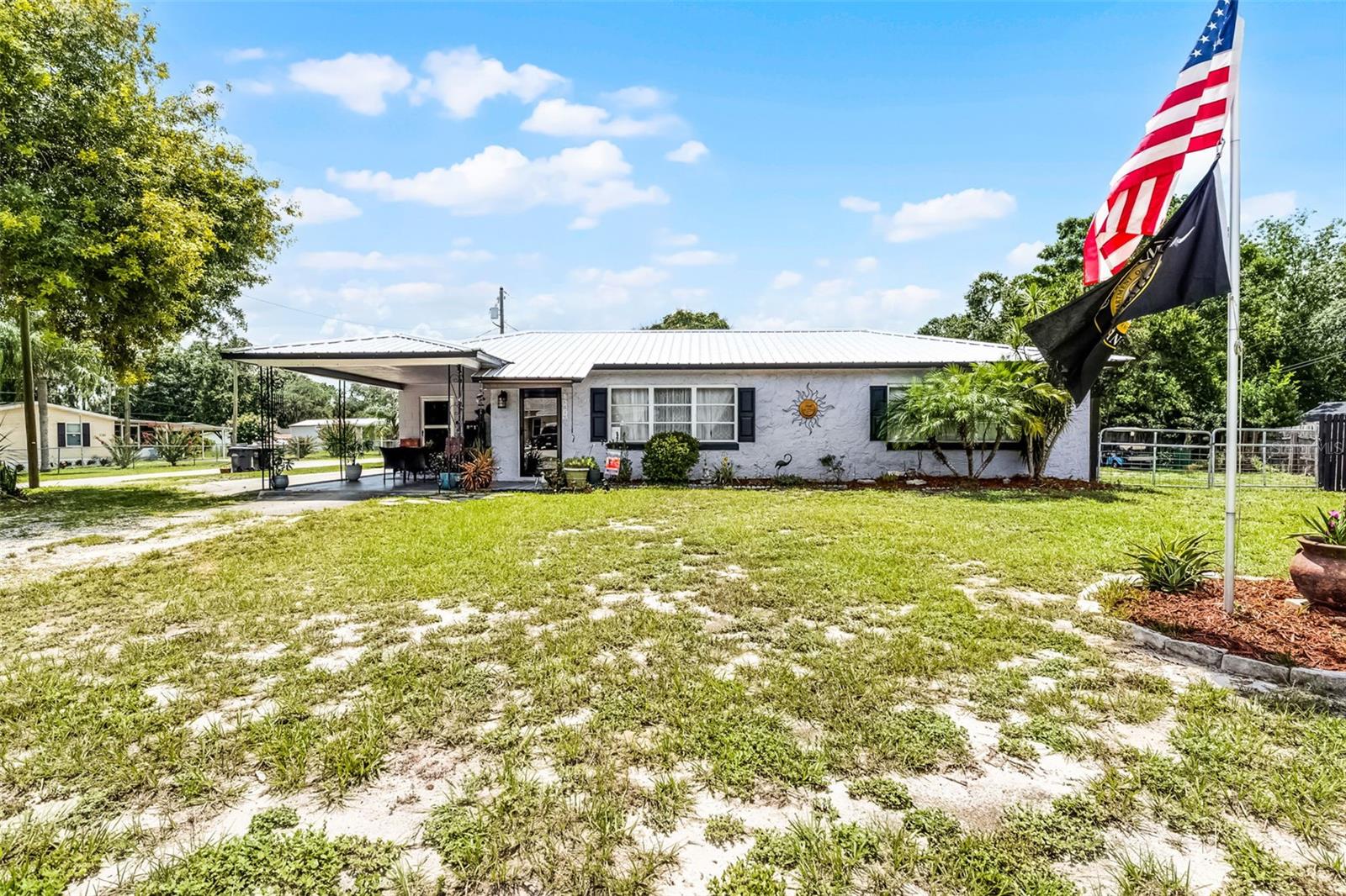 Located just minutes from the public boat ramp to Lake Pierce, this charming 2-bedroom, 1.5-bath home sits on a .28-acre corner lot with a fully fenced yard. Offering a blend of comfort and convenience, this property is ideal for those seeking relaxed living in a well-established, HOA-free community.
The home features an open-concept floor plan, with a spacious living room highlighted by oversized windows that fill the space with natural light. At the heart of the home is a functional kitchen with a large center island, stainless steel appliance package—including a propane gas range—and a pass-through window to the formal dining room, making entertaining a breeze.
The formal dining room offers direct access to the rear porch through sliding glass doors, while a large walk-in utility room adds valuable storage space. The primary bedroom includes warm wood parquet flooring and a 12x12 sitting room with private access to the back porch. The generously sized guest bedroom measures 17x12, providing ample space for family or guests.
Additional Features: Dedicated laundry room with half bath, Metal roof (installed 2018), Two storage sheds with electrical power, Parking pad for a 30 ft RV or Boat, 30 Amp Plug in outlet in backyard , Covered back porch and gazebo, One-car carport, Mature shade trees.
Enjoy country-style living with the added convenience of being just a short drive to shopping, dining, Bok Tower Gardens, and Legoland.