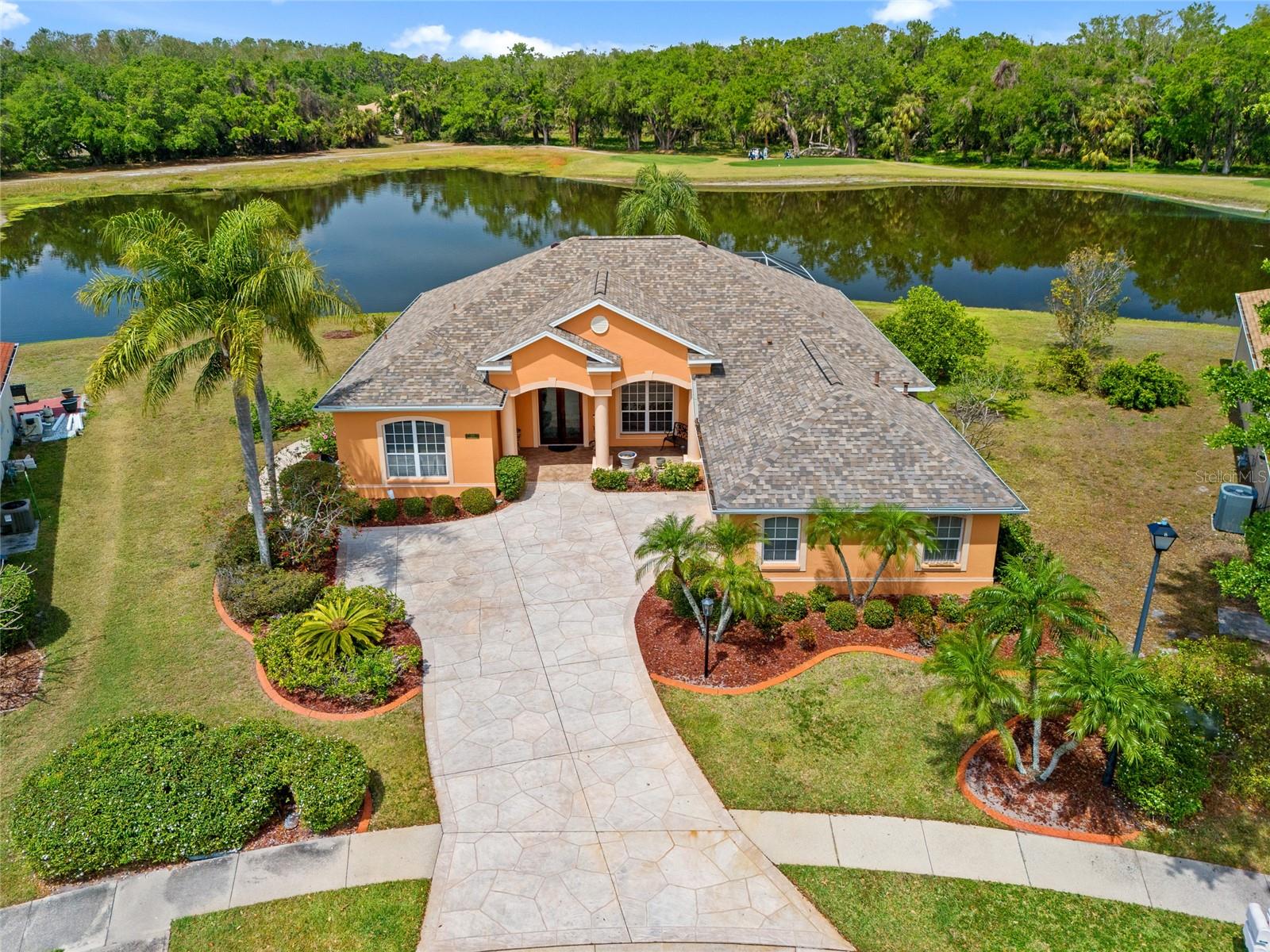 PLANTERS MANOR AT GREENFIELD PLANTATION! This beautifully maintained 3 bedroom plus office, 2.5 bath pool home on an oversized lot offers spectacular water and golf course views. From the moment you arrive, the home welcomes you with a covered front porch and elegant double glass front doors. A spacious 2-car side-entry garage completes the exterior, surrounded by mature, lush landscaping that enhances the home's curb appeal. Step inside to an open and airy floor plan with high ceilings, arched entryways, crown molding, ceramic tile and hardwood flooring, formal dining room, and formal living area with large slider to lanai and exceptional views. The home boasts a functional split floor plan, offering privacy and convenience. In addition to the 3 bedrooms, the office provides the perfect space for remote work or additional flexibility. The formal dining room is perfect for hosting guests, while the kitchen features granite counters, stainless appliances including gas range, center island with sink perfect for prepping meals and breakfast bar. The intimate dining nook with large aquarium window overlooks the family room with pocket slider to enjoy the serene lake views. The primary suite is a peaceful retreat offering 2 walk-in closets, slider to lanai and private en-suite with dual vanities, garden tub and walk-in shower. The outdoor entertaining area features covered lanai, convenient half bath, screened gas heated pool and spa, outdoor patio area for grilling and northwestern exposure to enjoy amazing sunsets. Low HOA and no CDD. Fantastic location close to I-75, restaurants, shopping at Heritage Harbour, schools, parks and home to public pay-to-play Links at Greenfield Plantation Golf Course. Easy access to fishing and boating on the Manatee River and relaxing on Bradenton beaches. Don’t miss the opportunity to make this well-maintained home with incredible views yours today!