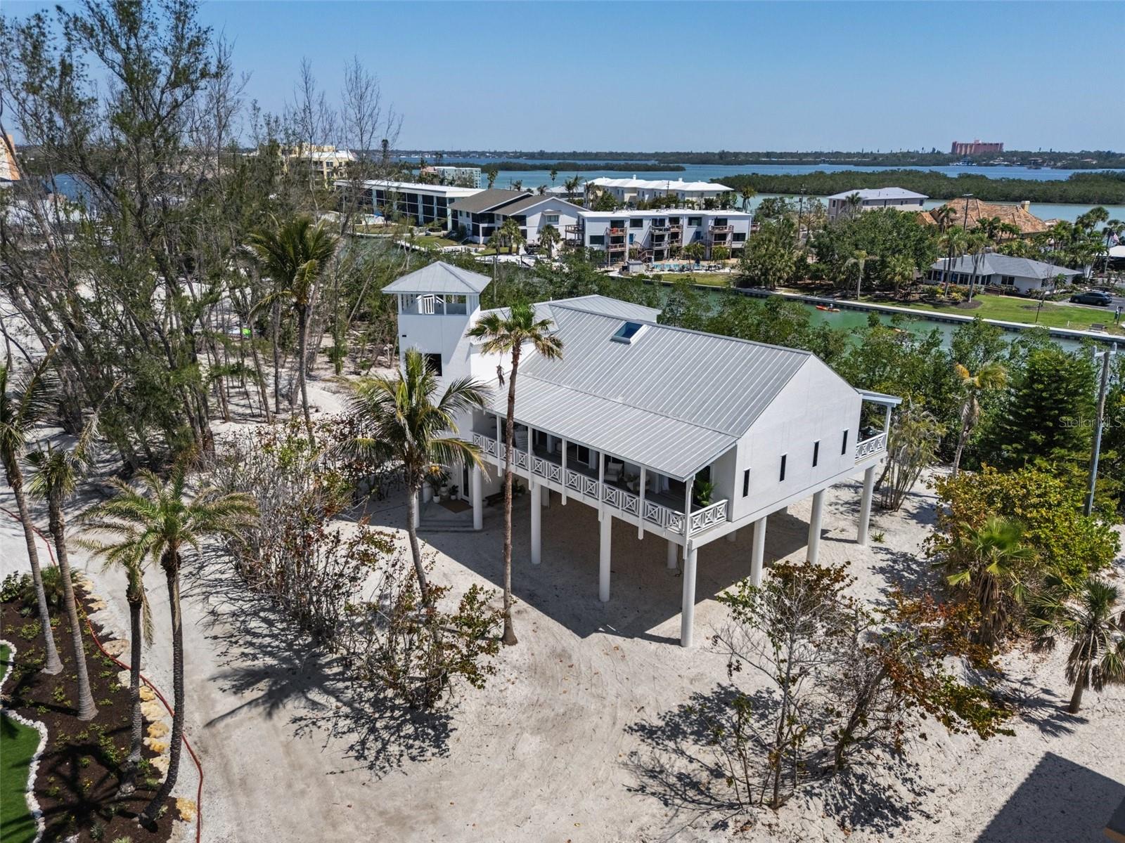 Gulf-to-Bay elegance meets coastal sophistication in this sailboat-access waterfront retreat, nestled in one of Siesta Key’s most exclusive gated communities. Located on a rare peninsula neighborhood offering true Gulf-to-Bay living, this elevated home provides unmatched privacy, beauty, and direct water access. Set on sailboat water with no bridges to the Bay, and with the newly reopened Midnight Pass just minutes away, this is truly a boater’s dream—offering effortless access to the Gulf of Mexico.
Inside, the home exudes refined coastal charm. A vaulted-ceiling great room is bathed in natural light and flows into a chef-inspired kitchen, beautifully equipped with premium appliances, including a Sub-Zero refrigerator. Perfectly designed for entertaining and everyday comfort, the open layout extends to dual covered terraces on both the east and west sides—ideal for savoring sunrise coffees and sunset gatherings with sweeping water views.
Built on pilings, the home offers a thoughtful combination of elegance and storm-conscious construction, providing peace of mind without compromising on style. The quiet dead-end street further enhances the sense of privacy, while generous under-home storage and covered parking offers practicality for everyday living.
Whether beach combing, or simply savoring the peaceful setting, this property embodies the best of luxury waterfront living - inspired by the elegance of Casey Key and timeless grace of Boca Grande.