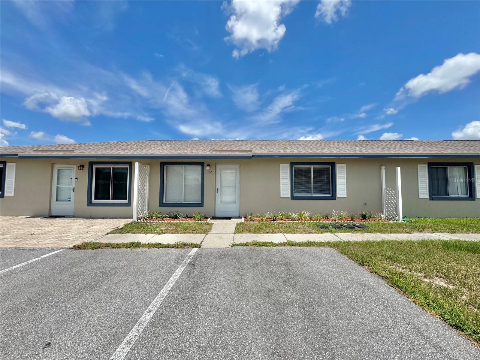 One or more photo(s) has been virtually staged. Tucked away in a waterfront community with direct access to the Chain of Lakes, Unit 112 offers serene lake views from the rear 8x18 screened-in lanai, making it the perfect backdrop for this 3-bedroom, 2-bath home that blends comfort, convenience, and exceptional value! Step inside to discover modern vinyl plank flooring throughout and an open-concept great room that flows seamlessly into the dining area and kitchen. The kitchen is fully equipped with stainless steel appliances, generous counter space, washer/dryer hookup and a pantry. From the kitchen, enjoy direct access to the spacious screened in lanai with lake views of Lake Conine – ideal for relaxing, dining, or entertaining guests. The spacious primary suite features dual closets and a private en-suite bathroom with a walk-in shower. Two additional generously sized bedrooms share easy access to the guest bath, which includes a tub/shower combo. Residents will enjoy the heated community pool, boat slip, dock, and direct access to Lake Smart—part of the beloved Chain of Lakes. Each unit is assigned two parking spaces right at the doorstep, with additional guest parking near the clubhouse. Embrace a low-maintenance lifestyle with an HOA that covers roof maintenance, exterior building care, beautifully landscaped grounds, road upkeep, and pool and dock maintenance. Quick commute to shopping, dining, Legoland, and located just minutes from HWY 27 with easy travel to both Tampa and Orlando.