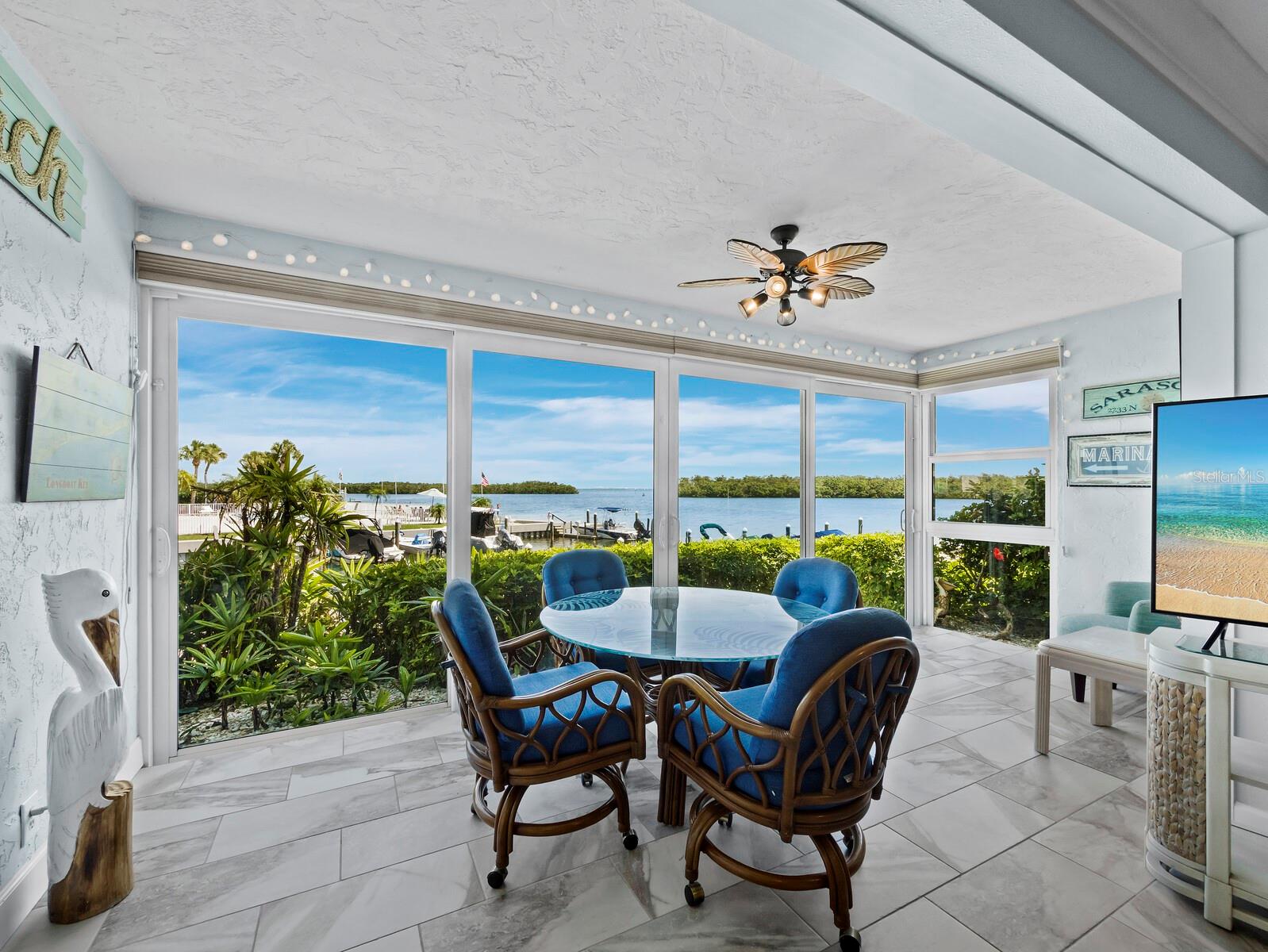 It's all about the spectacular FULL BAY VIEWS in this tranquil and beautifully renovated island retreat located in the beach to bay community of Sutton Place. This 2 bedroom, 2 bath residence is a true coastal oasis all done up in seaside hues. The gorgeous, remodeled kitchen is open to the living/dining area across an expanse of granite that includes a custom made dining table with lots of storage underneath and seating all around! Porcelain tile flooring makes the journey from one room to another a seamless and beautiful transition. These smart owners have converted the lanai into finished square footage and it is the perfect spot to enjoy a morning coffee or an evening beverage while watching the fish jump or the birds fly by. They also upgraded to IMPACT RESISTANT SLIDING DOORS AND WINDOWS throughout. The Primary bedroom has this same gorgeous view and a renovated ensuite bath. The once walk-in closet was converted to a small office space, (which could easily be changed back) but it’s current use is rather genius. When guests are not in town, the 2nd bedroom is another tranquil space to enjoy. Did I mention this is a 2 pets friendly community?! Sutton Place also offers its own PRIVATE BEACH CLUB and includes an abundance of amenities including 2 pools, a clubhouse, and an onsite marina with slips for a nominal fee of only $300 per year. The community recently completed a number of updates including repainting, reroofing and passing the milestone inspection and securing a 10 year certification. This owner has paid for all of those upgrades in full. The unit is being offered furnished with exceptions. Here you will find a remarkable quality of laid-back island life but if you're ready for more, enjoy the multitude of restaurants, shopping and the cultural mecca of downtown Sarasota, all within a short drive away.