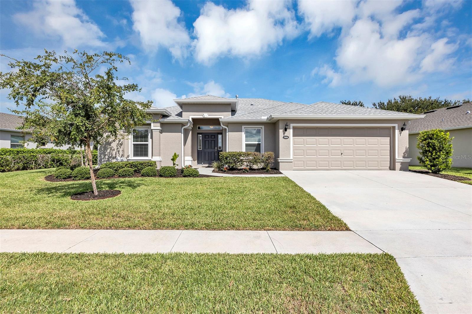 IMMACULATELY MAINTAINED 3 BEDROOM, 2 BATH LOW-MAINTENANCE STUCCO HOME BUILT IN 2021 WITH OVER-SIZED 2 CAR GARAGE WITH ADDITIONAL 8X16 GOLF CART AND STORAGE AREA IN AFFORDABLE, HIGHLY SOUGHT AFTER ARLINGTON RIDGE GUARD GATED GOLF AND ACTIVE-ADULT COMMUNTY. A mature, recently upgraded landscape package welcomes you to this beautiful home. Home has just been painted inside and out, All rooms have low-maintenance tile and main areas have 9 foot ceilings for a sense of more open space The modern open concept design has rounded corners on sheetrock, Kitchen features abundant wood cabinets w/ new back-splash and granite counter-tops with 4 seat bar-top dining & closet pantry. The stainless-steel 5 burner natural gas range and double door stainless fridge are included, The master bedroom features an en-suite bath with dual vanities w/ quartz counter-tops, a walk-in Roman shower for added safety, private water closet and extra Large walk-in closet. Indoor laundry room with new washer & dryer that stay. The open concept 18x20 Great Room is great for entertaining and the quadruple 8 foot tall sliding doors overlook the 330 s.f. lanai and bird cage w/a peek-a-boo view of the 15th T-Boxes and fairway. The back-yard is large enough to install a 12x24 pool, cage and patio. The proposed pool has been approved by the community and the city. Garage has pull-down stairs to attic with floored area for extra storage, Discover a lifestyle of comfort and leisure you've waited for your whole life for, Very Low HOA of $125 per month includes, mowing, trimming & blowing of lawn Wi-Fi router for signal coverage throughout the home, 200+ cable TV channels, and 250-megabyte high-speed internet. Two DVRs are also included for recording your favorite shows which is all included, Low-maintenance stucco construction. situated near the golf course by 15th T-Boxes, Sidewalks and underground utilities for more luxurious feel. Split Plan for guest bedrooms provides ultimate privacy. Benefit from huge discounts and very affordable homeowner's insurance (CURRENTLY $1,223/YEAR!) due to the home's high construction standards being built to wind code, high & dry elevation for flood protection, and a low wind zone, also qualifying for additional insurance discounts. The low HOA of $125/month makes this community even more affordable than nearby communities, With most of the yardwork done for you, What will you do in your spare time? This coveted community offers a wide range of amenities, including an 18-hole golf course where you can get a tee time year round, driving range, putting greens, YOU DO NOT HAVE TO PURCHASE A SOCIAL OR GOLF MEMBERSHIP TO LIVE IN COMMUNITY OR PLAY GOLF, lighted tennis and pickleball courts, heated swimming pools, hot tub, fitness facilities, billiards, a restaurant, tavern, and a free movie theater. The community is golf cart-friendly, with sidewalks for strolls and low-speed limit streets perfect for bicycling. Enjoy the convenience to grocery stores, restaurants, banks, and pharmacies within a 5-minute drive. Emergency services are just 10 minutes away, and a free boat ramp and fishing pier on a 15,000-acre lake are nearby. Community is 20 minutes from malls, restaurants, and a 12-screen movie theater, 45 minutes from Orlando, Major theme parks, and the airport, 90 minutes to Daytona Beach & Atlantic Ocean and Gulf of Mexico Clearwater. SJS 2025©
