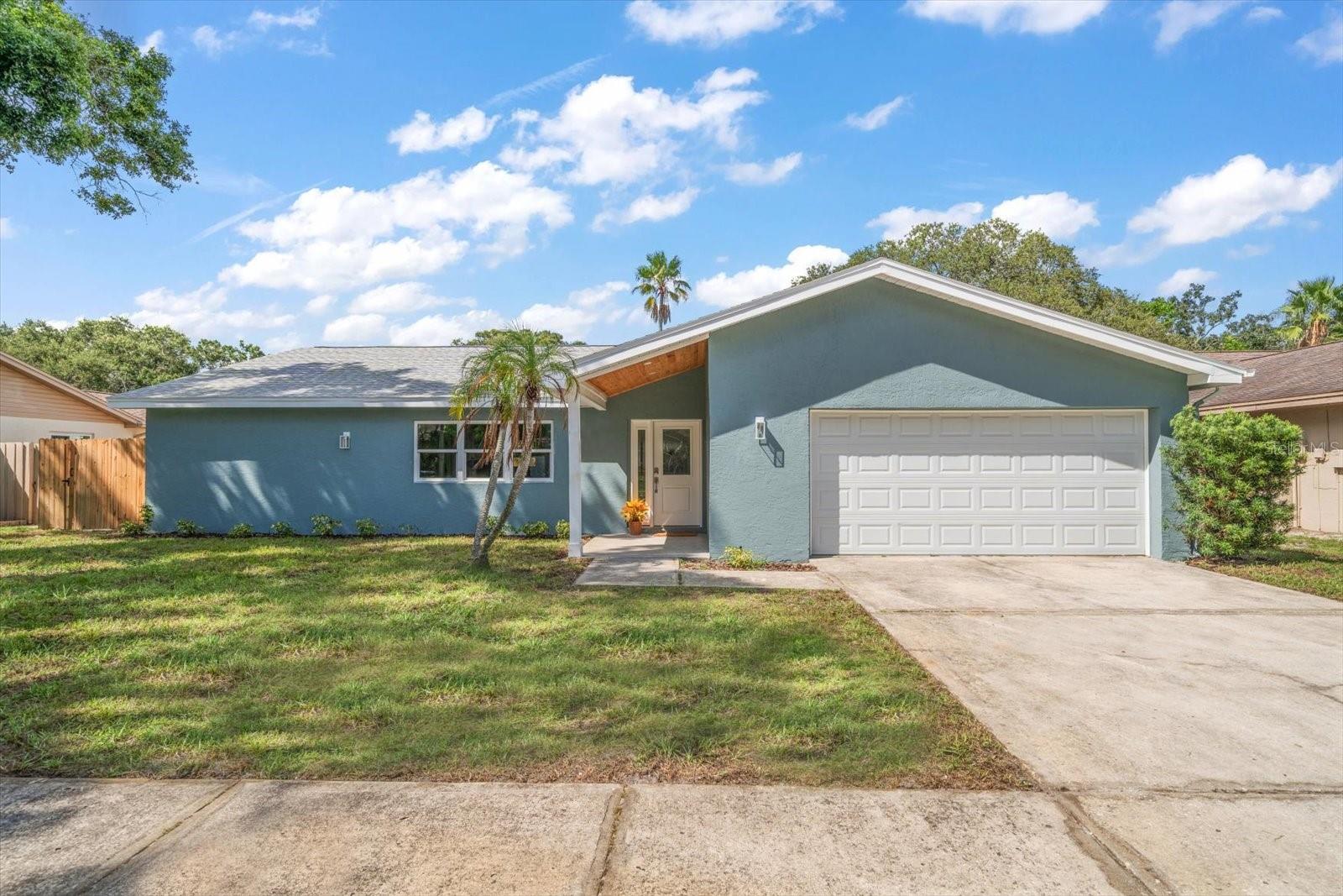 Completely renovated and move-in ready, this stunning pool home perfectly combines modern style, comfort, and convenience in a highly sought-after location. Just steps from the scenic beauty of Walsingham Park with its fishing, walking trails, and abundant wildlife, this home is nestled in a quiet neighborhood close to top-rated schools, restaurants, and shopping. Inside, a bright open-concept floor plan welcomes you with gorgeous flooring flowing throughout and a gleaming white kitchen at the heart of the home, featuring an apron-front farm sink, new stainless steel appliances, pendant lighting, and an extravagant island with storage and seating. The dining area sits adjacent to the kitchen, ideal for entertaining and informal gatherings, with sliders that open to the private and fenced backyard oasis where a sparkling pebble tech pool, covered dining area, pavered pathways, and green spaces create the perfect outdoor gathering spot. The desirable split-bedroom plan includes a spacious, light-filled primary suite with a walk-in closet and spa-inspired ensuite boasting a furniture-style double sink vanity, a massive walk-in shower, and direct access to the pool. Two additional bedrooms offer plentiful closet space and share a sleek, modern hall bath with a tub/shower combo and custom finishes. With all-NEW impact windows/sliders, roof, pool equipment, water heater, paint, appliances, and meticulous updates throughout, this home is a rare find in a prime location that balances tranquility with everyday convenience.