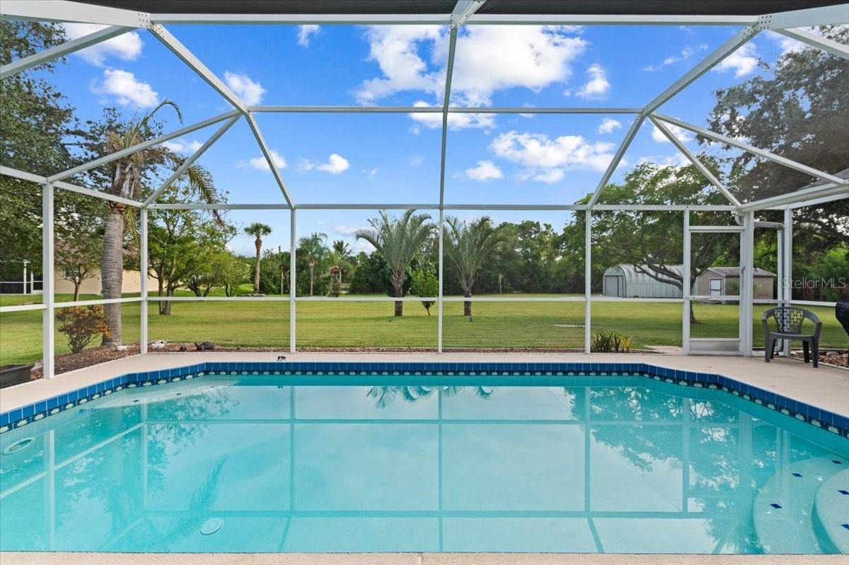 Welcome to 8335 Drolet Ave., where you’ll find the rare combination of nearly an acre of cleared land, pool, and over 2,000 sq ft of smartly designed living space. Inside, a large open kitchen with breakfast bar and space for a table overlooks the pool and yard, which is perfect for relaxed mornings with coffee or lively evenings with friends. The family room offers generous proportions to accommodate the biggest sectional and movie-night at home. The primary suite is something you’ll look forward to: French doors opening to the lanai, dual vanities, a garden tub and a separate shower stall for true owner-suite luxury. Two additional bedrooms and a second full bath provide real flexibility for guests, a home office or hobby space.
Everyday living is effortless thanks to major system updates: a roof installed in 2020, a new water heater in 2024, newer well pump and reverse-osmosis at the kitchen sink, plus a recently serviced septic system (Jan 2024). The inside laundry room with cabinets and sink combines practicality with convenience.
Outside you’ll appreciate the extra space. With nearly one acre of land you have room for toys, tools, gardens, RV or boat parking without the constraints of a typical subdivision lot. A large Quonset-style shed provides additional garage or workshop space beyond the standard two-car garage, and a separate garden/lawn tool shed keeps everything tidy. The pool and lanai offer your own private resort feel, right in your backyard.
This home is ideal for anyone looking to upgrade to a lifestyle of space, privacy and comfort, whether you’re relocating, downsizing but not compromising, or simply stepping into your forever-home. With move-in ready systems, pool and acreage, you’ll spend more time enjoying and less time maintaining.
Schedule your private showing today to see how 8335 Drolet Ave. could be the place where your Florida-living dreams become reality.