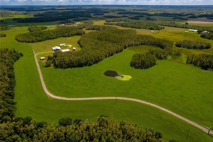 New listing that includes 2 parcels totaling 132 acres. Experience your very own private oasis on this breathtaking 132-acre ranch located in Lakeland, Florida. This property is a true hidden gem featuring a stunning 3-bedroom, 2.5-bathroom barndominium built in 2019. With 2200 square feet of living space, full wrap-around porch, an open floorplan, grand ceiling heights, and rustic-style barn wood tile flooring throughout, tons of storage, custom designer features throughout, this home is a sight to behold. The gourmet kitchen is a chef's dream, boasting soapstone countertops, solid wood cabinetry, live edge wood accents, stainless steel appliances, and stone backsplash. The master bedroom is thoughtfully designed with a resort-inspired bathroom that exudes serenity and functionality with double sinks, soapstone countertops, and a HUGE walk-in shower. The his/hers closet is spacious and provides ample storage for more than just your wardrobe. In addition to the stunning home, this property boasts several highly productive hay fields and excellent hunting opportunities, making it a great source of income. The 4 large newly fenced pastures are set up for rotational grazing to help ensure the land does not get over-pressured. You'll appreciate the convenience of a gated and paved private driveway, solid-covered working cow pens, an 8-inch commercial-grade well, and multiple ponds for watering cattle and fishing. The metal-trussed barns provide outstanding storage and add to the functionality and convenience of the ranch. There is a fully covered RV barn 24x36 with a 50amp power hookup, water, a detached full bathroom, and an apartment. The large 58x60 barn has power, water, and a concrete slab. There are two additional barns 16x36 and 30x60 with a 14x40 lean that are currently used for equipment and hay storage. Nestled in a serene and peaceful environment, this property provides the perfect place to unwind and relax. The tranquil surroundings add to the charm of this ranch, making it an ideal place for those seeking a quiet and peaceful life away from the hustle and bustle of the urban sprawl. With its breathtaking views and abundant natural beauty is a rare find that offers a unique opportunity to experience the joys of country living at its finest.
