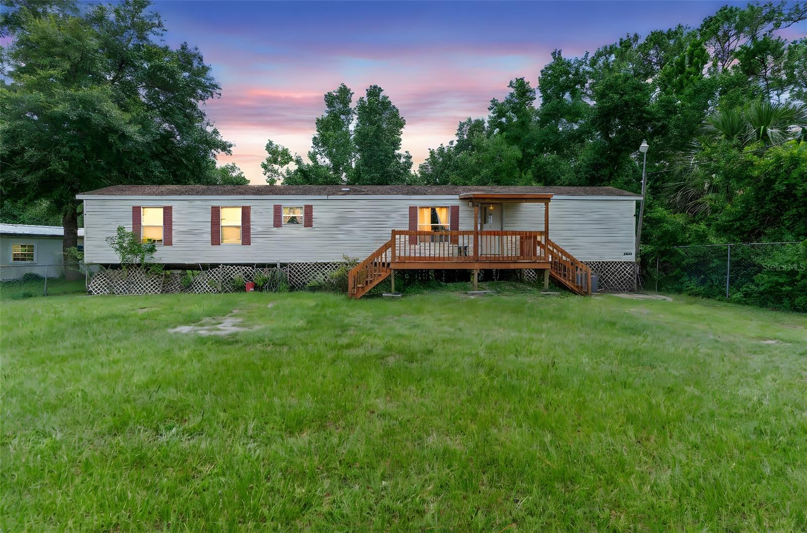 Under contract-accepting backup offers. DELAND: **HIGHEST AND BEST BY WEDNESDAY, JULY 16TH 11:59PM**Welcome to country living at its best! This 2 bedroom 2 bathroom Mobile home sits on an oversized .32 Acre lot. The lot is fully fenced including a gated entrance to the driveway. Enjoy being surrounded by nature and while the location is secluded it is only 15 min to shopping, restaurants and all DeLand has to offer! The front porch is the perfect spot to enjoy morning coffee and watch the fur pets run around. The living room features large windows for natural light to flood the home and a ceiling fan to keep you cool. The open kitchen has plenty of counter and storage space for easy meal making and there is room for a dining area to enjoy family dinners. The primary bedroom is spacious and French doors lead to the En Suite bathroom. The bathroom has a garden tub-the perfect spot to unwind after a long day. There is an additional bedroom and guest bathroom. Inside utility which makes doing laundry quick and easy. Outside shed for storing of lawn equipment and tools. The yard has plenty of room for everyone to run and play! Make your appointment today to see all this home and property has to offer you!