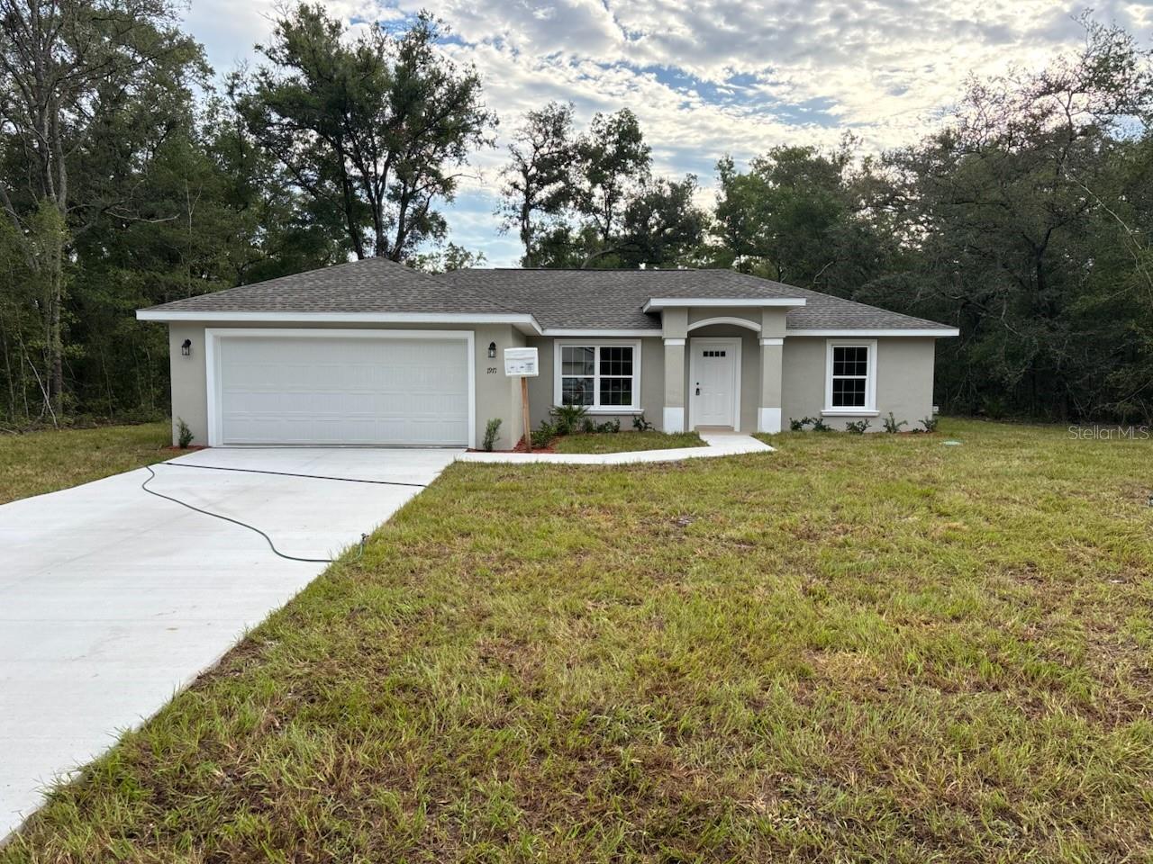 NEW CONSTRUCTION. MOVE-IN READY! This beautiful Islamorada model in Citrus Springs offers 3 bedrooms, 2 bathrooms, and 1,438 square feet of thoughtfully designed living space. Built with solid concrete block construction and topped with a durable 30-year architectural shingle roof, this home combines style with lasting quality. Inside, you'll find a bright living room with a vaulted ceiling, energy-efficient double-pane windows, and luxury vinyl plank flooring throughout. The kitchen is both functional and stylish, featuring stainless steel appliances, custom white shaker cabinets with soft-close drawers, wrap-around cabinet layout, granite countertops, a pantry, and a classic subway tile backsplash. Both bathrooms are finished with upgraded marble-look tile, with a tub/shower combo in the main bath and a glass-enclosed shower in the master suite. The laundry room includes an upgraded cabinet package for added convenience. Step outside to enjoy a covered patio and a soon-to-be-installed privacy fence along the back. Additional highlights include an attached 2-car garage with opener and remotes, no HOA fees for added freedom, and location in flood zone X, which is high and dry and does not require flood insurance. The home also features an aerated septic system and comes with a 10-year structural warranty for peace of mind.