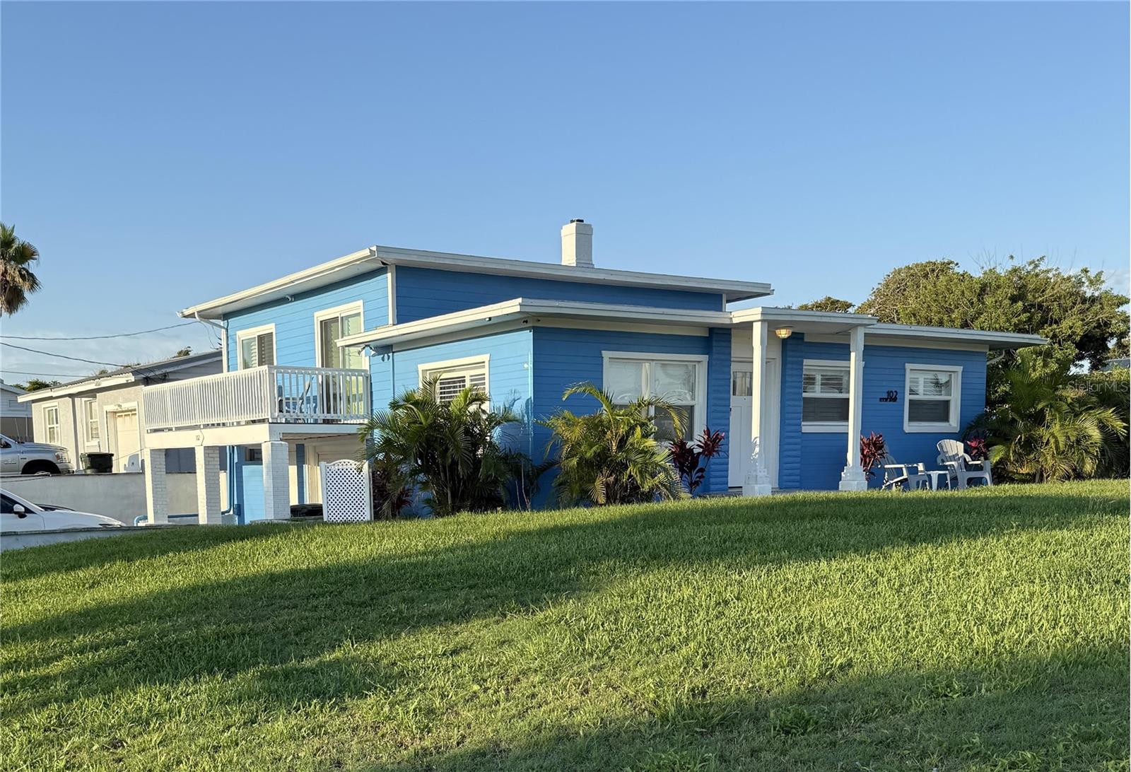 Don’t miss this beautifully remodeled, TWO-STORY BEACH HOME located on a desirable CORNER LOT just TWO BLOCKS FROM THE BEACH! This solid CONCRETE BLOCK CONSTRUCTION home features a brand NEW ROOF, NEW PLANTATION SHUTTERS and countless updates throughout. Upstairs, two east-facing bedrooms boasts PRIVATE BALCONIES, perfect for enjoying the ocean breeze. The UPDATED KITCHEN includes SOFT CLOSE CABINETRY, SOLID SURFACE COUNTERTOPS, and modern appliances. You'll love the warmth of HARDWOOD OAK FLOORING throughout the living spaces, with CERAMIC TILE in the kitchen and bathrooms for easy maintenance.
The oversized TWO-CAR GARAGE is located beneath the home, offering the potential for a home gym, playroom, or additional storage. A spacious driveway provides ample parking.
Step outside to your extended WRAP-AROUND DECK, ideal for relaxing or entertaining, surrounded by LUSH VEGETATION for added privacy. The home also includes a STORAGE SHED, GUTTERS, and a WASHER & DRYER, which convey with the sale.