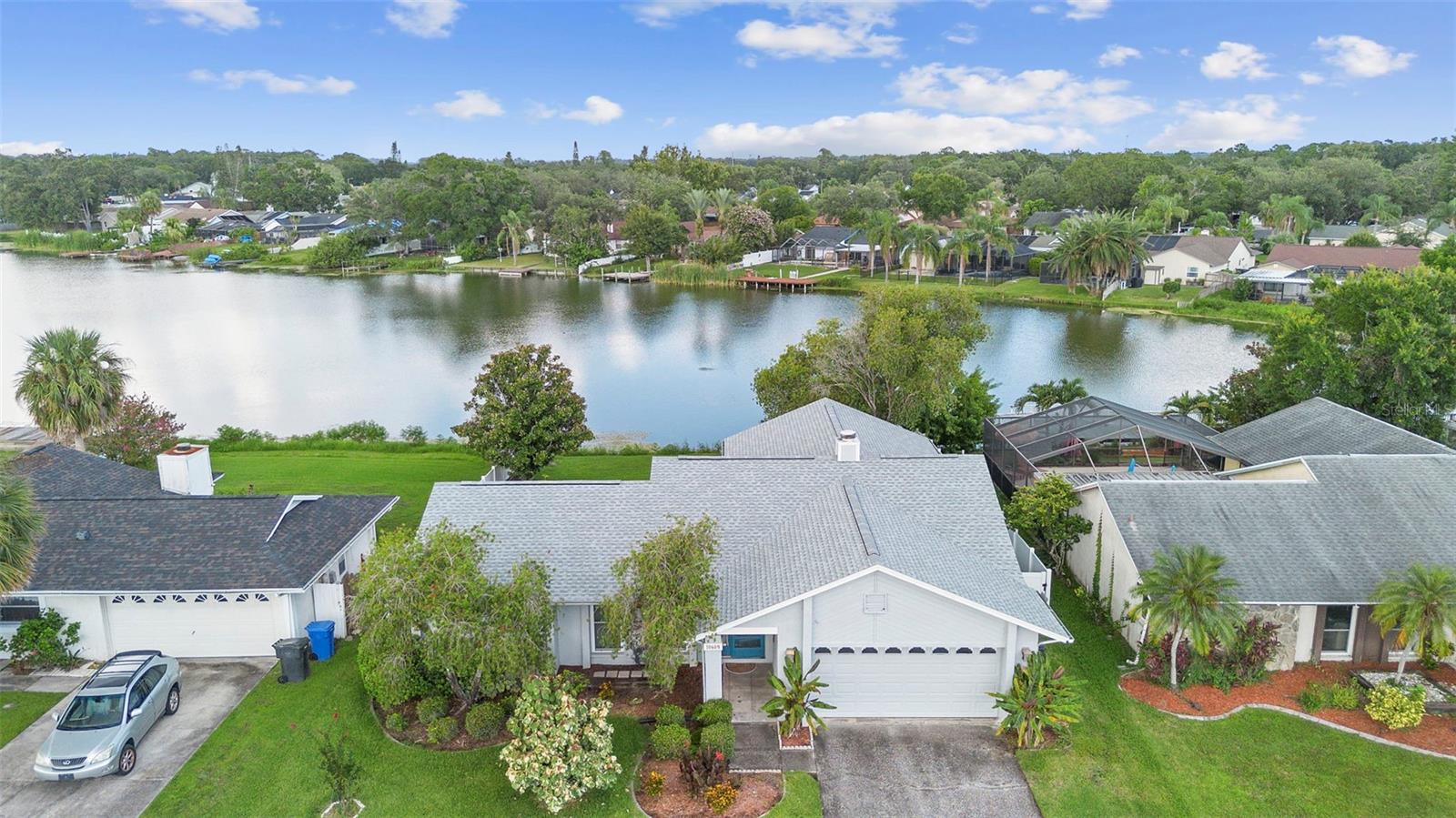 Auction Property. Auction Property. In Collaboration with Alex Cooper Auctioneers. List price is Opening Bid at The Online Only Auction Sale to Be Held on The Auctioneers Website – Bidding begins Thursday, August 7 & ends Tuesday, August 12, 2025 at 12:00PM. Charming Waterfront Residence Located in the Serene Bay Port Colony Neighborhood of Tampa. This charming single-story home offers approximately 1,702± square feet with 4 bedrooms and 2 bathrooms, set on a beautifully landscaped 0.16± acre lot.
Welcome to your own slice of paradise! This stunning property offers direct lake access—perfect for boating,
kayaking, paddleboarding, or simply enjoying peaceful water views right from your backyard. Whether you're an
outdoor enthusiast or just love the serenity of the water, this home brings lakeside living to your doorstep.
Enjoy a desirable split floor plan that offers privacy and functionality, along with a cozy wood-burning
fireplace that creates a warm and inviting atmosphere—ideal for cooler evenings or relaxed gatherings.
Step outside to a private backyard oasis filled with mature flowering trees that attract beautiful blue
herons and snowy egrets, creating a picturesque and tranquil setting that feels like a true retreat. With
lush landscaping and direct access to the lake, your next adventure is always within reach.
Tucked away in a quiet neighborhood yet close to local dining, shopping, and beaches, this is a rare
opportunity to enjoy the Florida lifestyle to the fullest. Don’t miss your chance to own this waterfront gem!