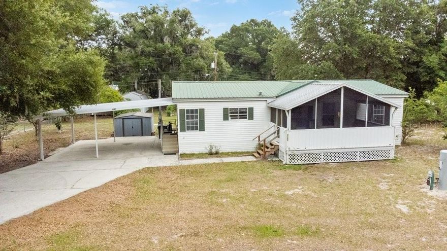 Welcome to your own private slice of country charm in Lakeland! Tucked away down a quiet dirt road, this property sits on over half an acre of beautifully treed, fully fenced land offering peace, privacy, and room to spread out. A very large screened-in front porch invites you to relax and enjoy the serene surroundings, while the durable metal roof adds both character and long-lasting value. With gorgeous mature trees, plenty of outdoor space, and the tranquil feel of old Florida living, this property offers the perfect escape while still being conveniently close to town.There is a 2 space attached carport with covered staircase into the home. Walk through the front door into the open living room and dining room. The large living space offers new LVT flooring throughout main living areas and kitchen! Don't miss the high ceilings and large windows that draw in beautiful natural light. Kitchen offers open concept with plenty of counter space for prepping and entertaining. Primary bedroom is a great size and offers walk-in closet and en-suite bathroom with stand-up shower and separate garden tub. Moving through to the other side of the home you have 2 additional bedrooms and a full bathroom. Bring your boats, toys, pets, and dreams...there's room for it all here!