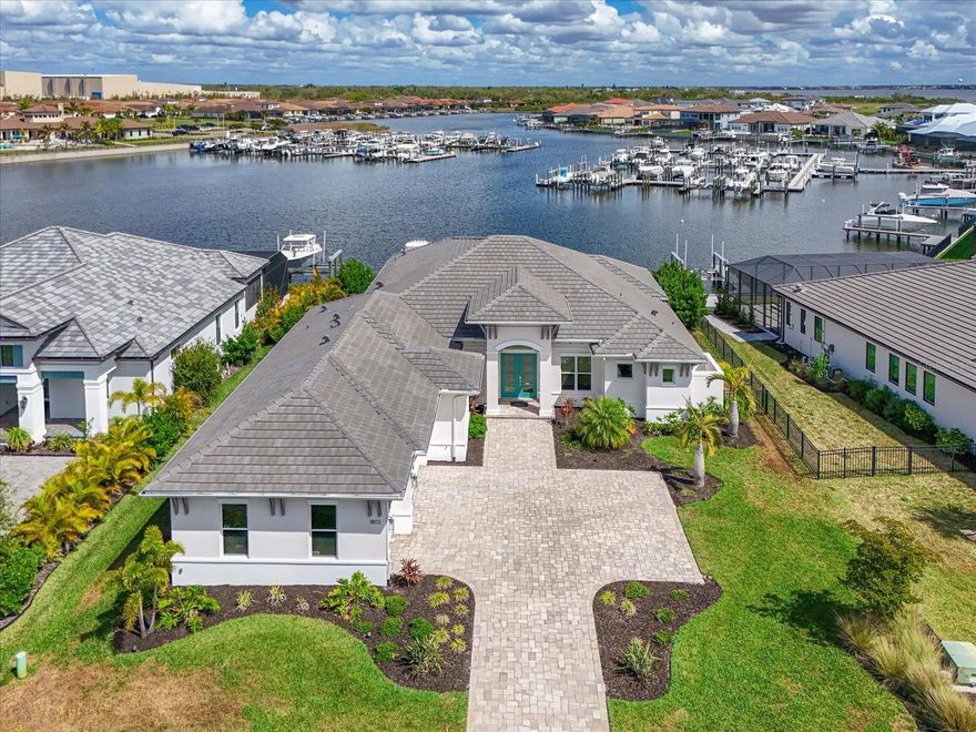 Come fall in love with this gorgeous 2023 Lee Wetherington luxury home in gated Sanctuary Cove!  Why wait for new construction when you can move right in to this "like new" pristine 3bd/3ba plus pool bath home offering a premier sunrise waterfront lot with marina views and direct walk-out to your private dock w/13,000-lb boat lift, water & power.  In addition to the 3 bedrooms this home also boasts 2 home offices or dens that can easily convert to more bedroom space. Built for peace of mind with a tile roof, impact windows/doors, whole-home generator (natural gas), tankless water heater, smart thermostat/security, and natural gas. Chef’s kitchen with Monogram appliances, gas cooking, quartz counters, large island + hidden walk-in pantry. Expansive sliders create seamless indoor/outdoor living to a heated/chilled saltwater pool & spa, covered lanai w/outdoor kitchen, fenced yard + outdoor shower. Side load 3 car garage w/epoxy floors. Two system zoned HVAC. Sanctuary Cove offers a true resort-style lifestyle with a heated community pool, fitness center, and a beautiful clubhouse featuring a party/gathering space with a full kitchen—perfect for hosting and celebrating. Residents also enjoy monthly community activities that make it easy to connect with neighbors and feel right at home. Plus, the community’s locked boat access adds an extra layer of privacy and security by helping prevent outside boat traffic from entering the community waterways.  Don't miss out on this rare gem, call today for your private showing!