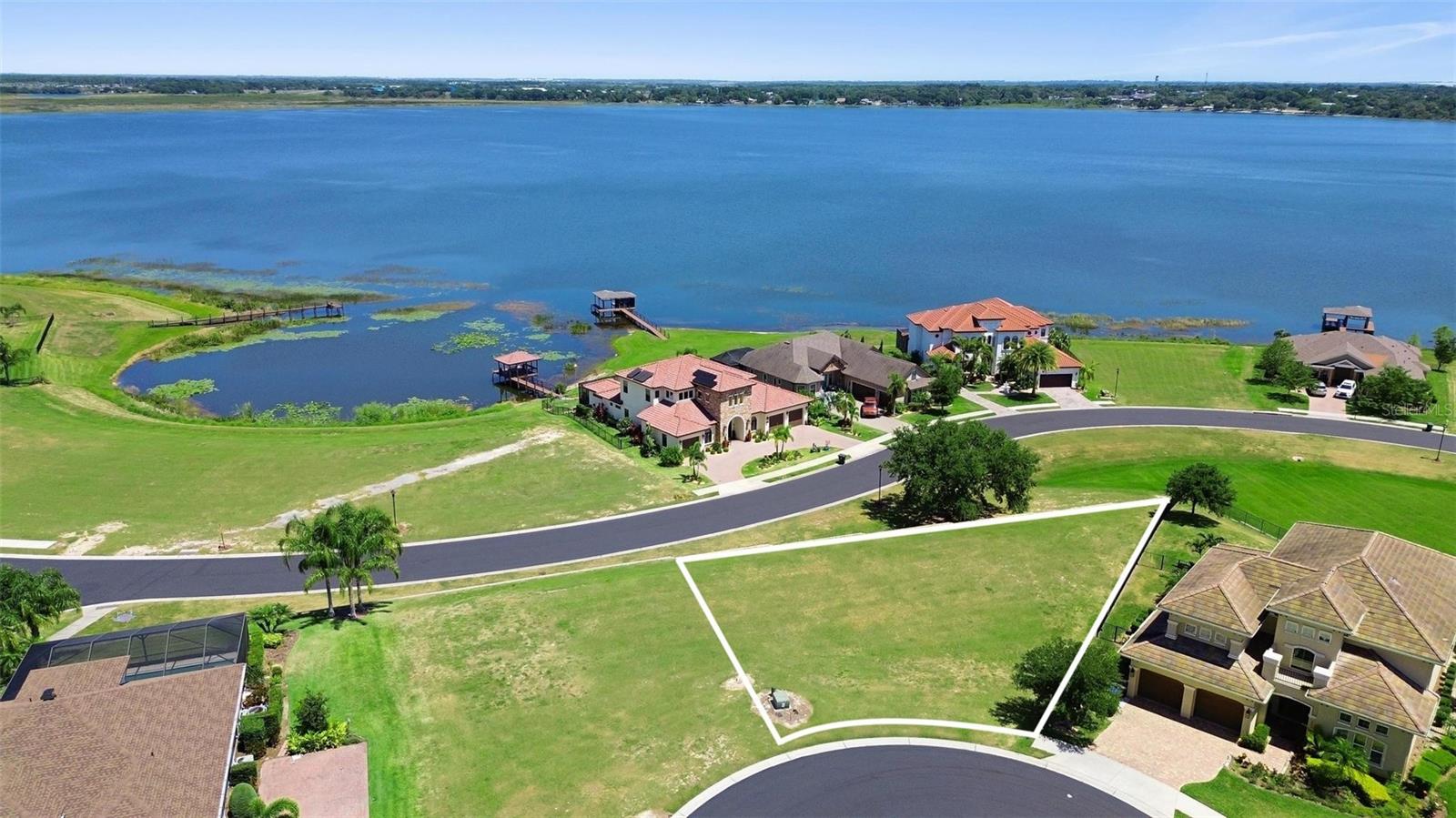 Build your dream home on this cleared, leveled vacant lot with a panoramic view of Lake Alfred, offering stunning scenery and extra privacy—all with no timeframe to start construction! Located in the prestigious Water Ridge community, enjoy resort-style living with access to 3 sparkling pools, 2 boat ramps, pickleball and tennis courts, basketball, a state-of-the-art fitness center with sauna and lockers, fishing piers, and boat & jet ski storage. All just 40 minutes from Disney and close to everything Central Florida has to offer. This is lakeside living at its finest!