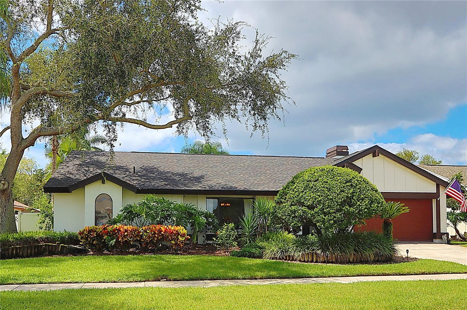 Welcome to the private gated community of Sweetwater at Rockypoint. This custom Arthur Rutenberg-built residence is ideally located just 3 minutes from Berkeley Prep, 7 minutes to Tampa International Airport, and only 30 minutes to the beach, perfectly balancing convenience, luxury and lifestyle. Situated on one of the highest elevations in Sweetwater, this spacious 4-bedroom and 2-bath home has never flooded, with no insurance claims, offering peace of mind for years to come. The spacious entry foyer leads to the vaulted ceiling family room, featuring a newly modeled, soaring wood burning fireplace that opens to the bright kitchen. The kitchen boasts all stainless steel appliances, white cabinets with granite countertops, a breakfast bar, and a breakfast nook. Enjoy a split bedroom layout with a spacious private primary ensuite featuring a tasteful barn door leading to the generous bathroom including two separate vanities, remodeled tiled shower, a separate garden tub, and an oversized walk in closet. Updated Bamboo wood flooring and the wood plank porcelain tiles flow throughout the home. The kitchen, primary suite, and former dining room lead to an expansive screened lanai with a sparkling pool, though sliding glass doors to entertain year round. The mature landscape, with a private, fenced backyard, includes a beautiful waterfall pond, creating an oasis of tranquility. This meticulously maintained home, which blends comfort, style, and nature in perfect harmony, is ready for a new homeowner!